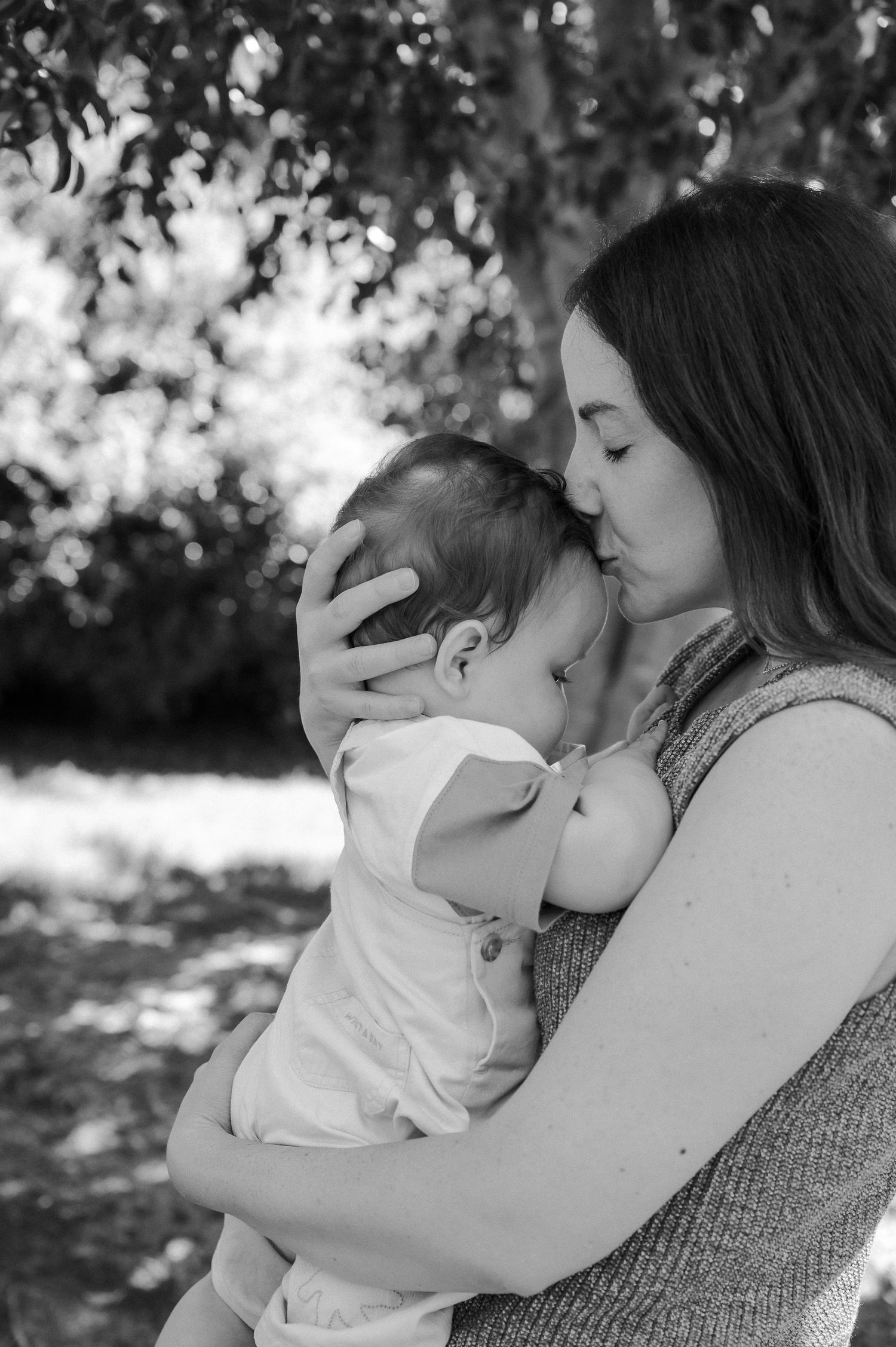 Black and white family photography Adelaide of mother kissing child