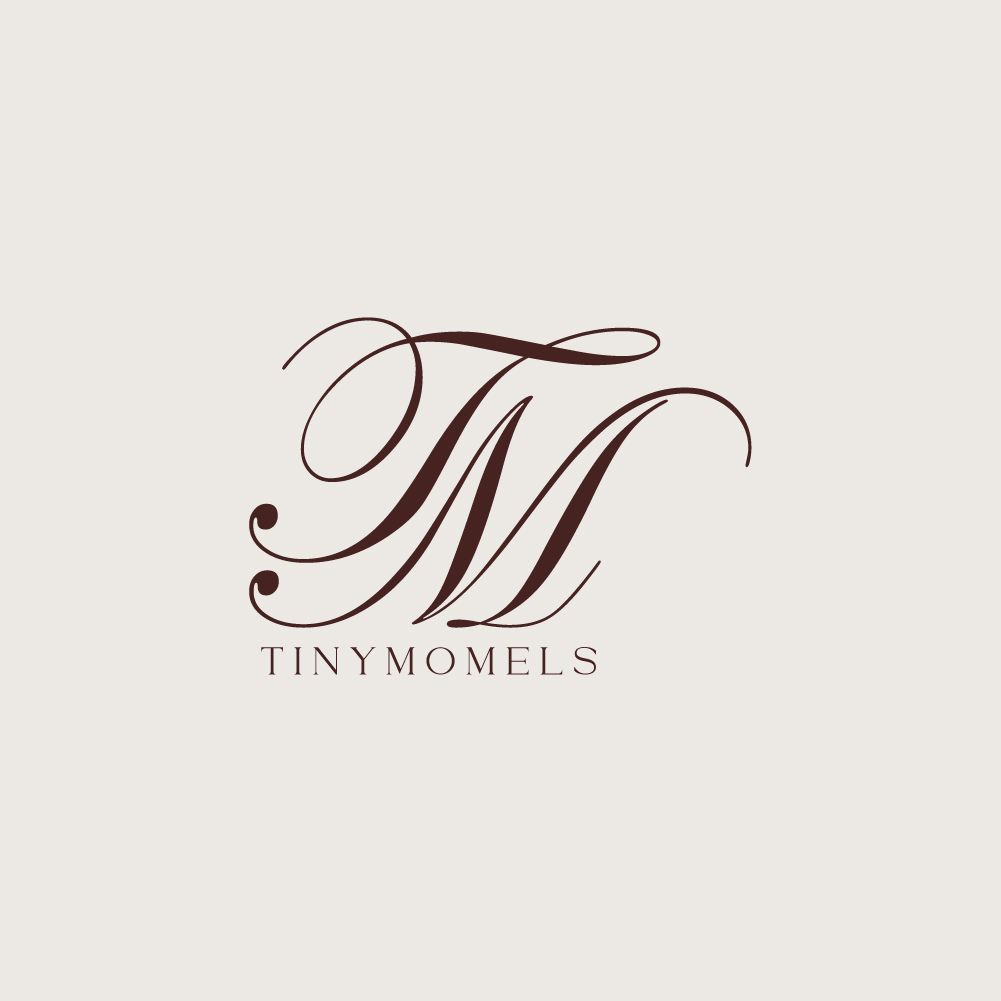 Elegant TM monogram logo for Tiny Momels in dark rose script on cream background.