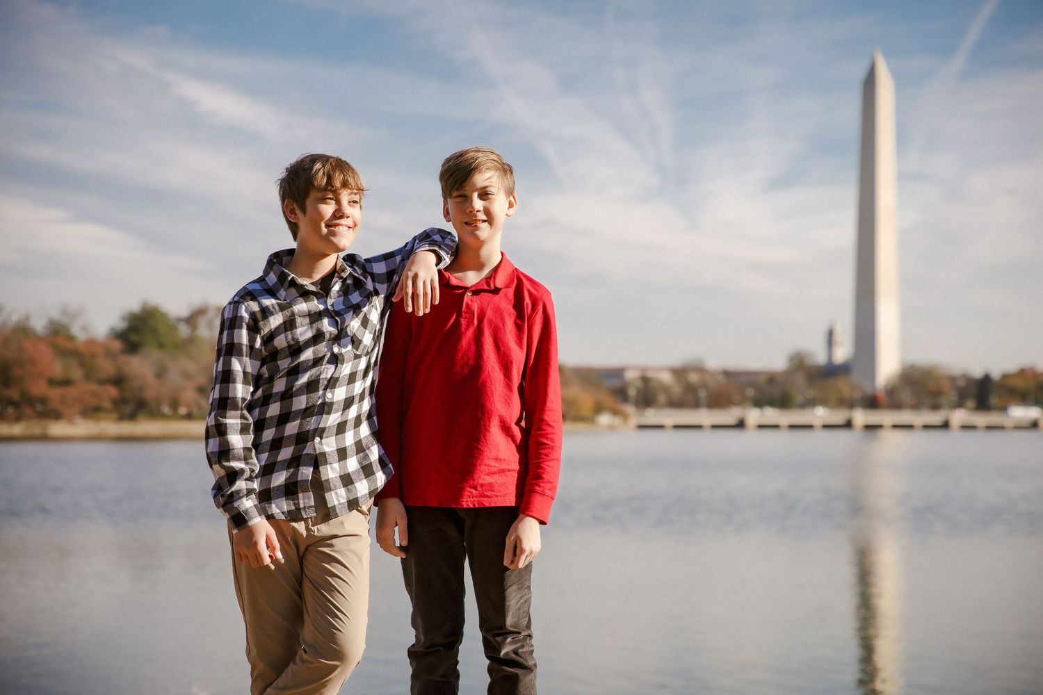 Two teenage boys pose together near the Washington Monument and Tidal Basin.