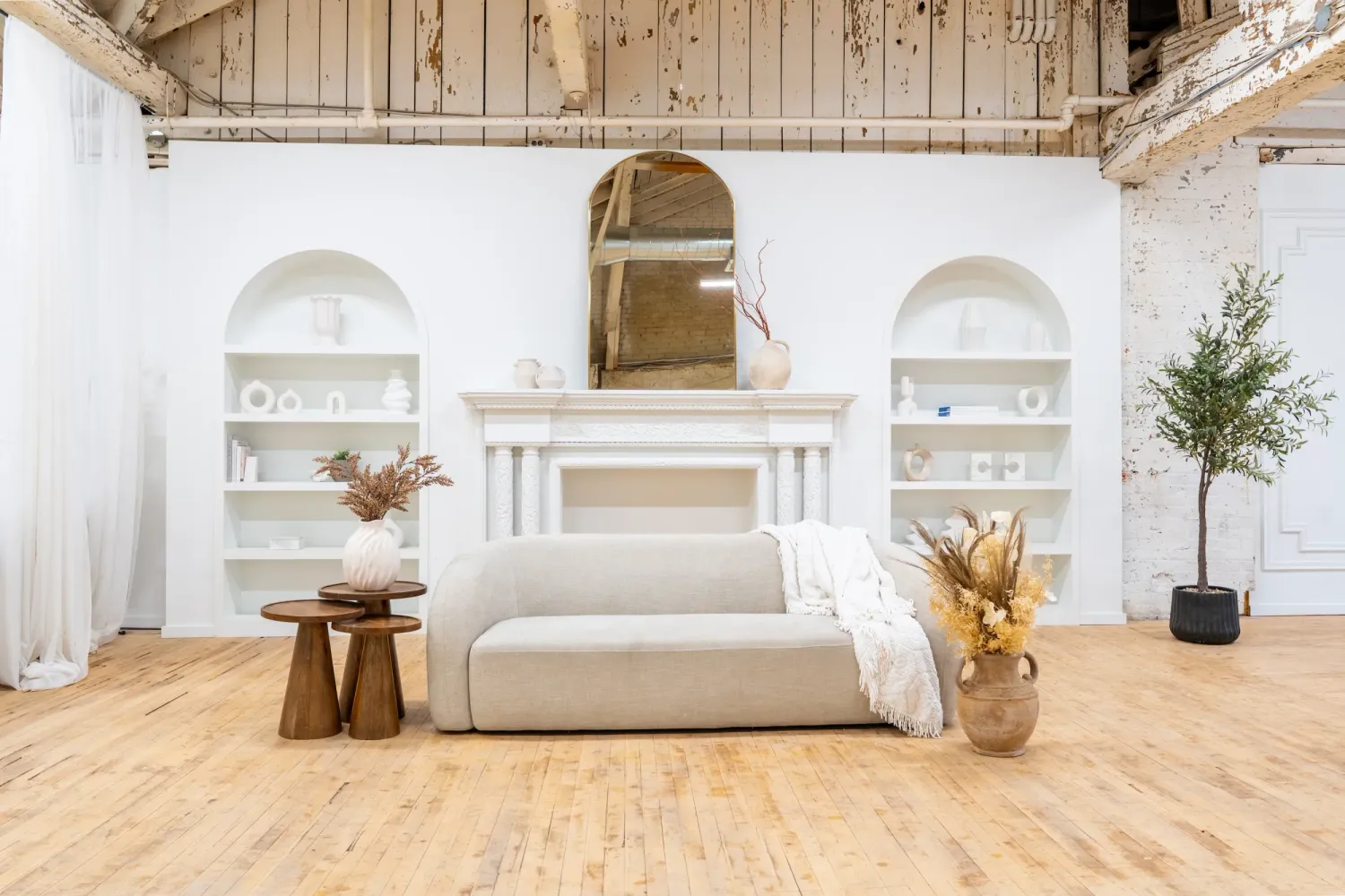 Modern photography studio with natural wood flooring, arched windows, and multiple rooms. Millworks Creative, Hamilton
