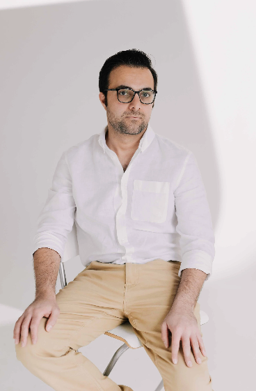 Professional wearing a crisp white button-down shirt and khaki pants poses against a light background in studio portraits.