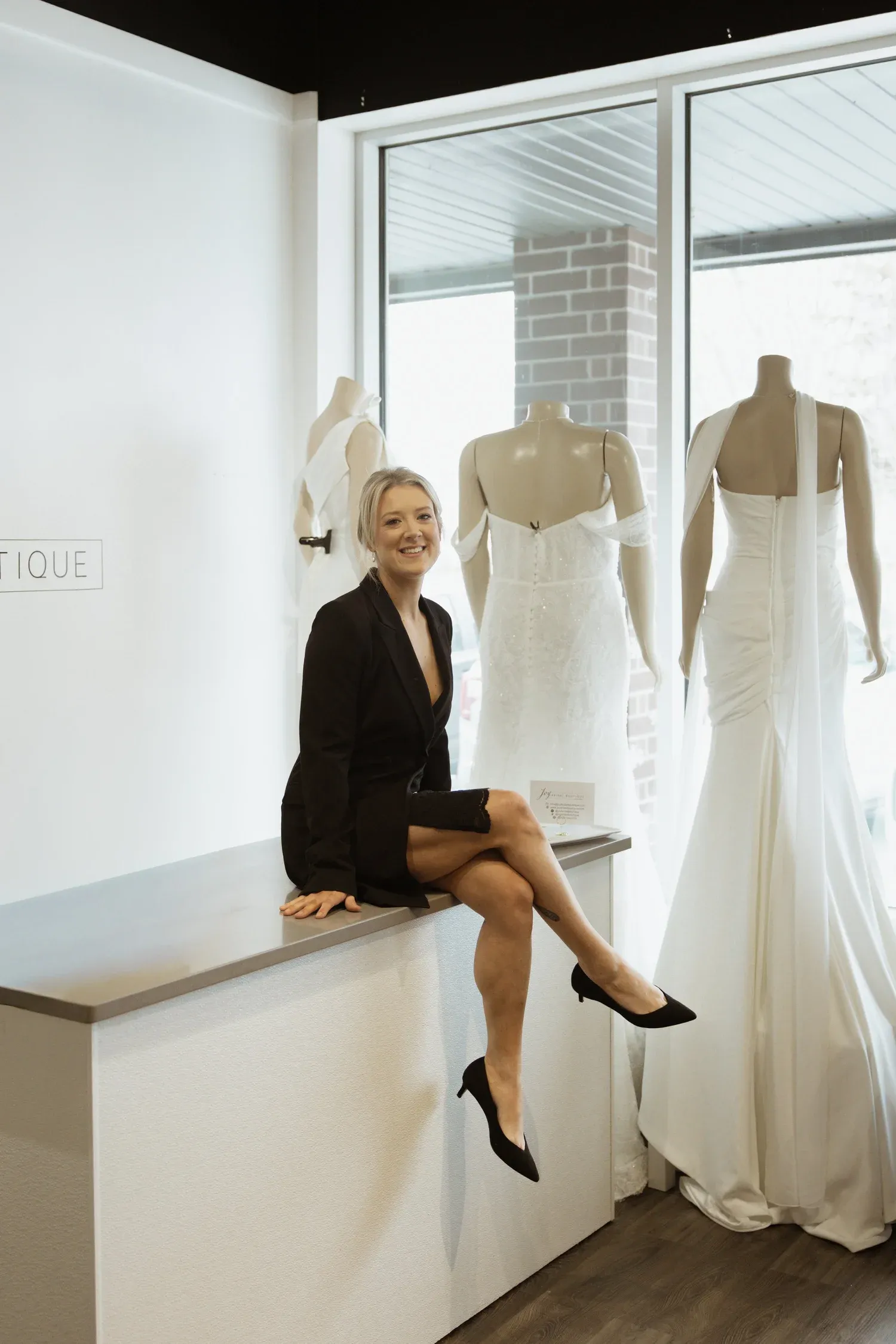 A fashion photography series showing white wedding dresses on mannequins with artistic poses against a bright studio backdrop.