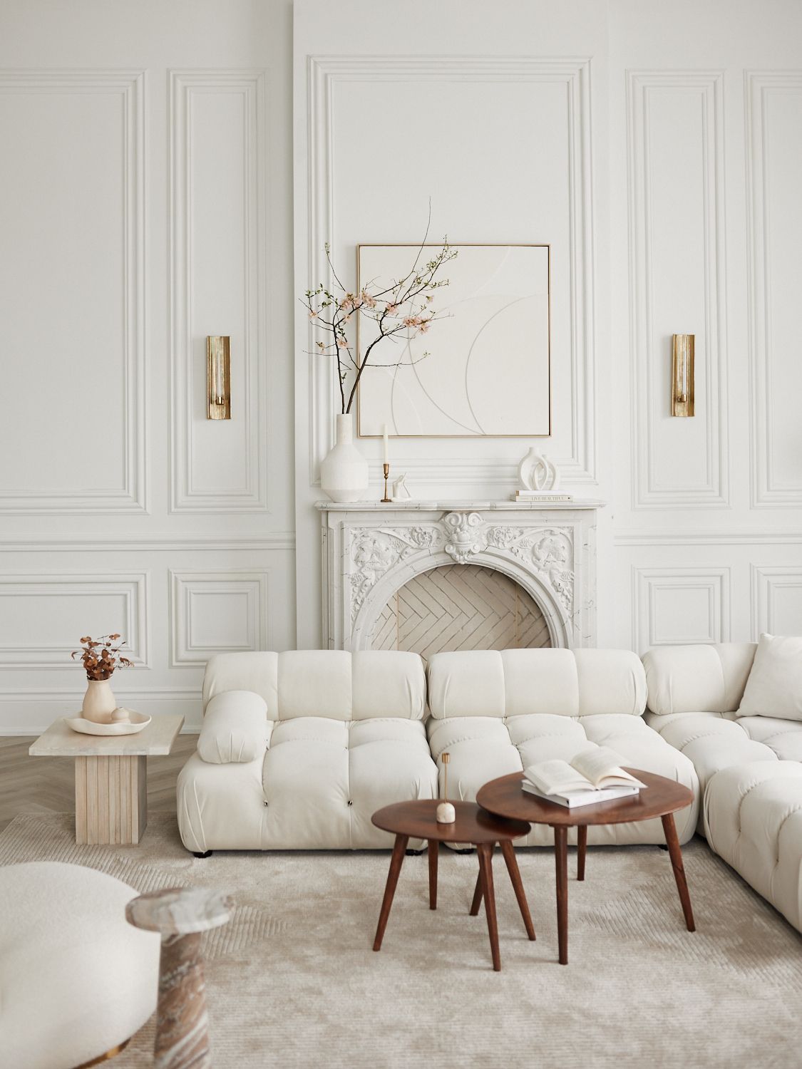 Modern white living room interior with luxurious sectional sofa, wood accents, and elegant wall paneling details. Mint Room Studio, Toronto