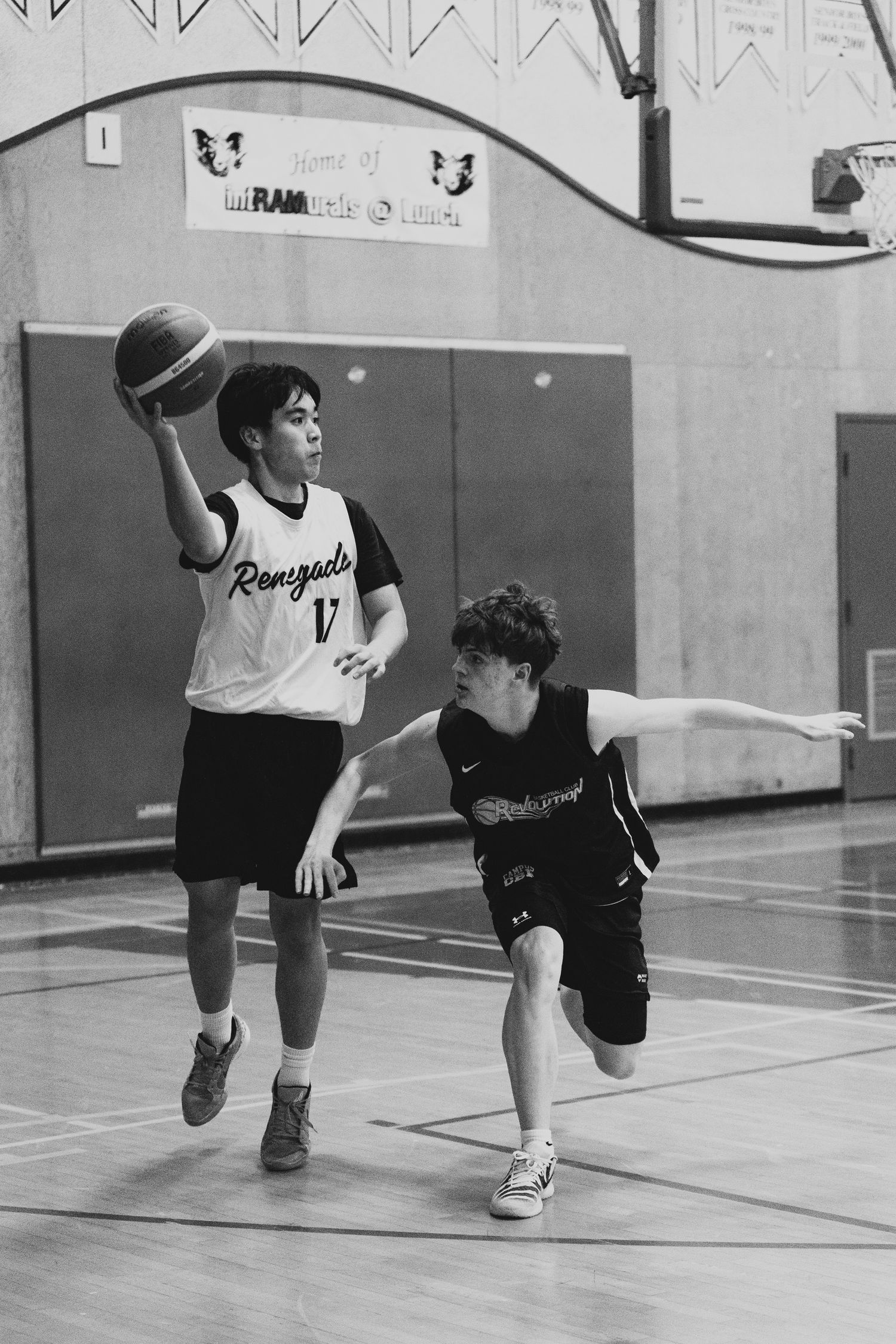 Renegades player #17 elevates for a shot while defender attempts to block in gym.