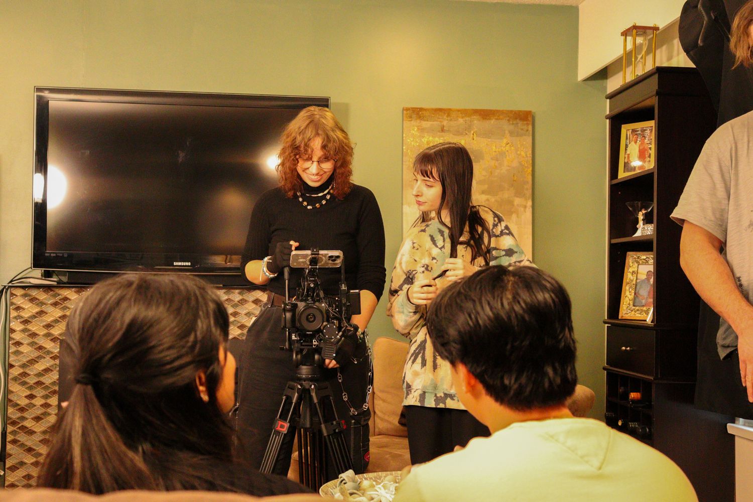 Director and actress review scene on film set with camera crew in foreground.