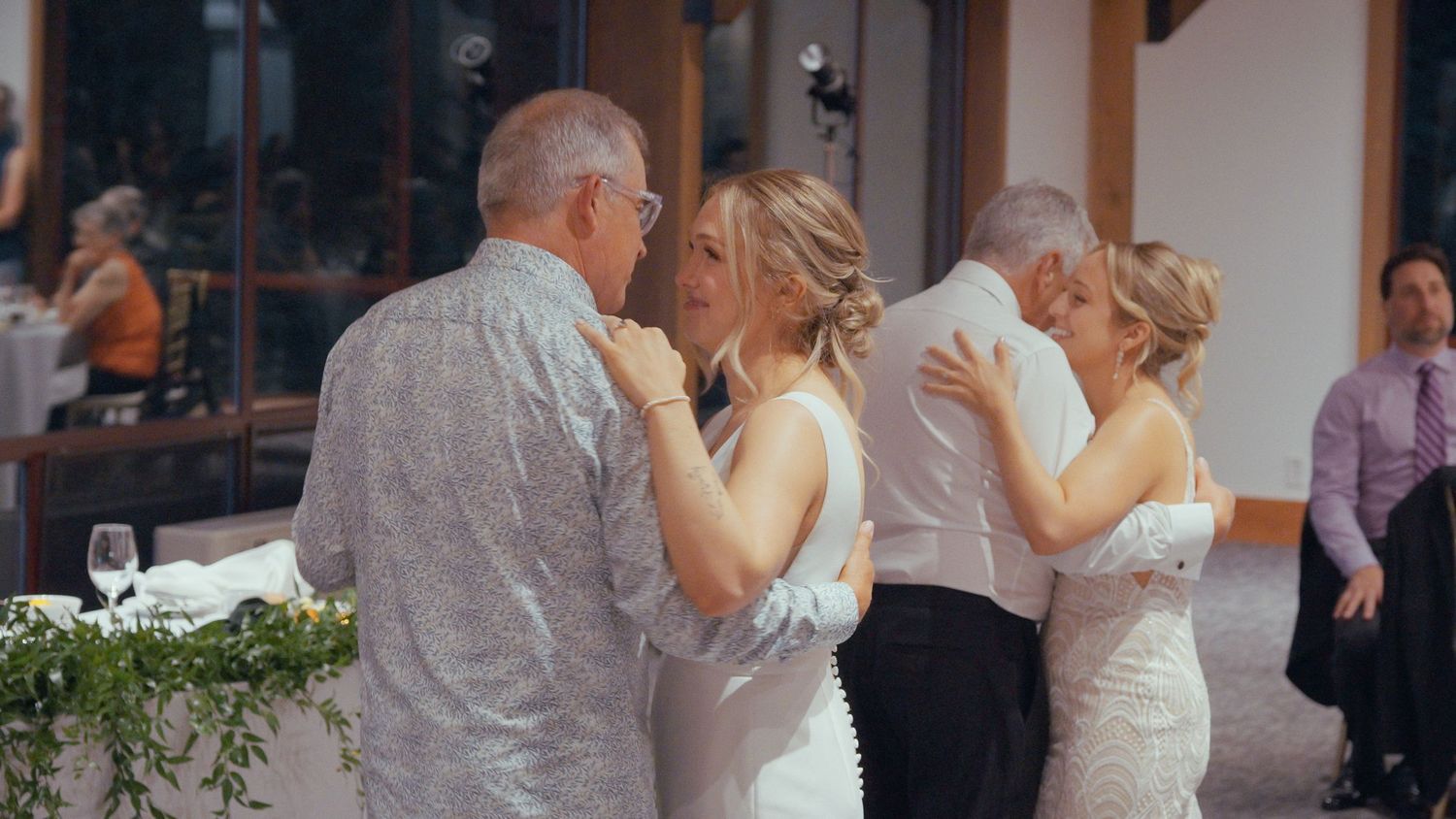 Bride sharing emotional dance with family members at wedding reception venue.
