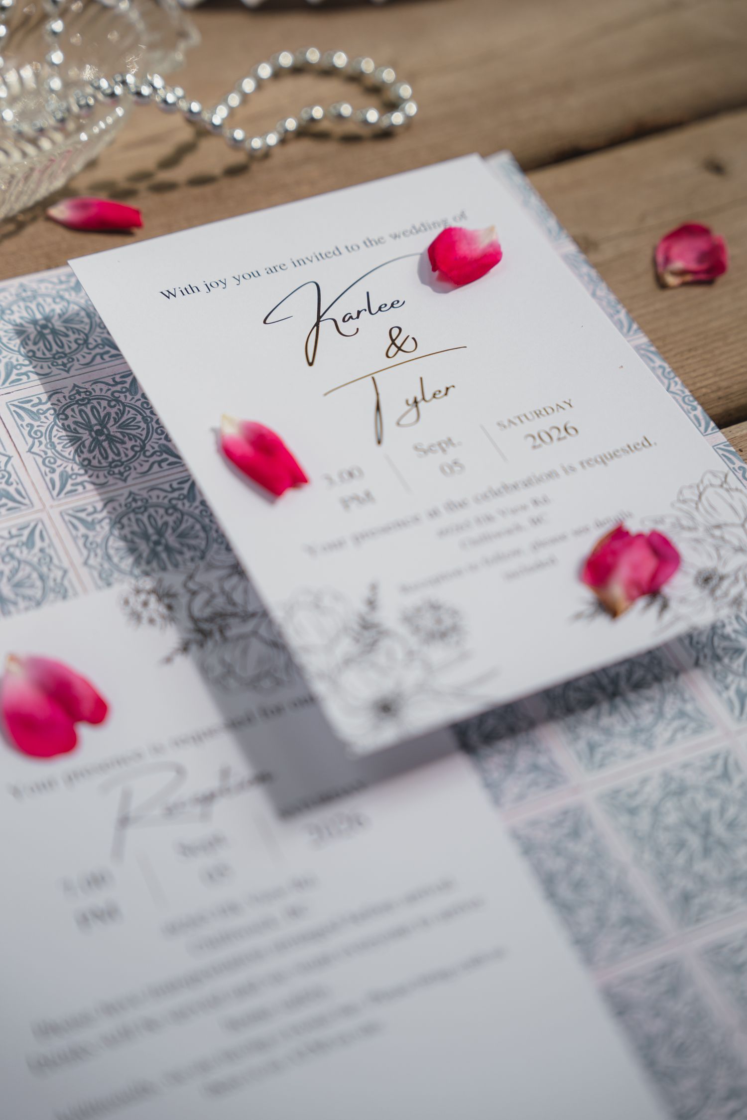 Elegant wedding invitation suite for Karlee and Tyler, dated September 5, 2026, adorned with pink tulips on wood.