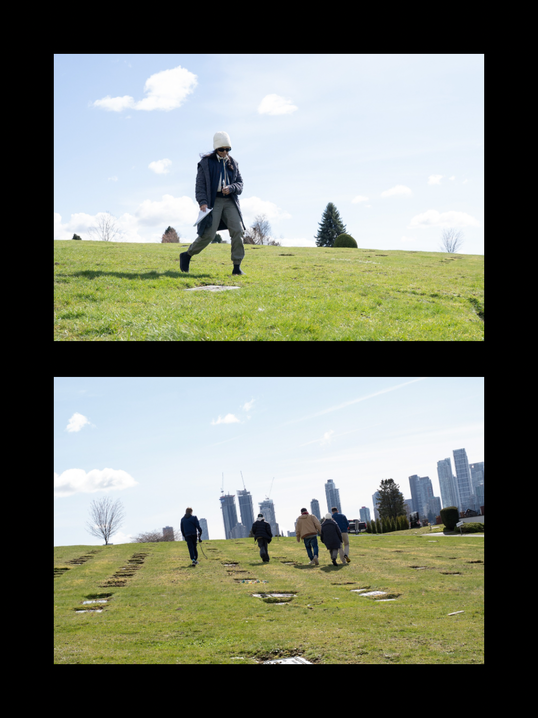People walking across a grassy hill with a city skyline visible in the background on a sunny day.