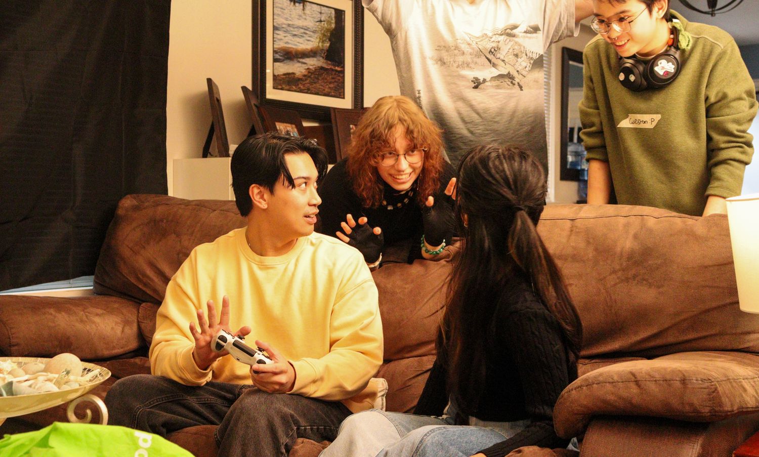 Director guides actors on couch during indoor film production scene.