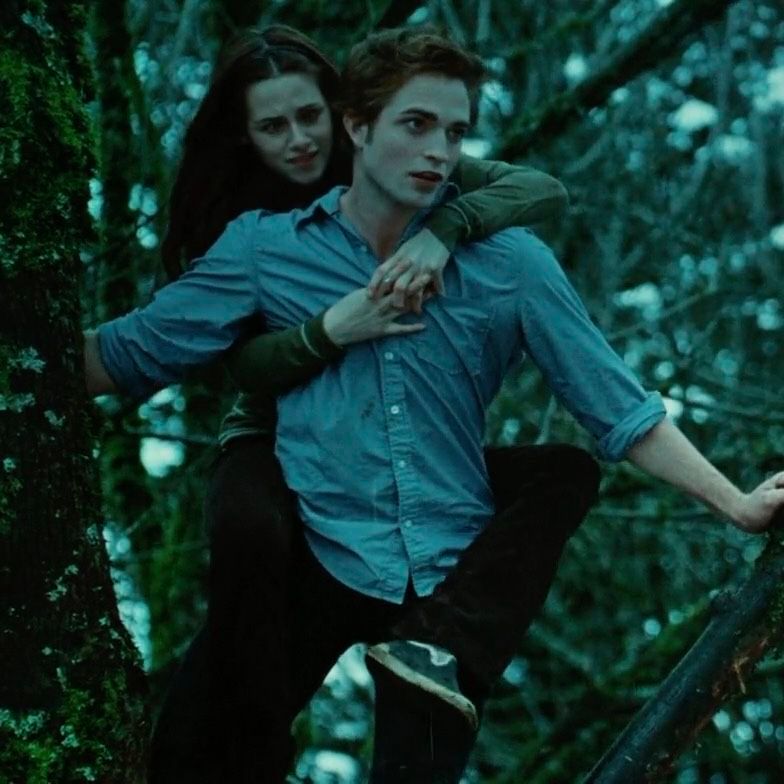 A young couple embraces in a misty forest, the man in a blue shirt holding the woman with dark hair.