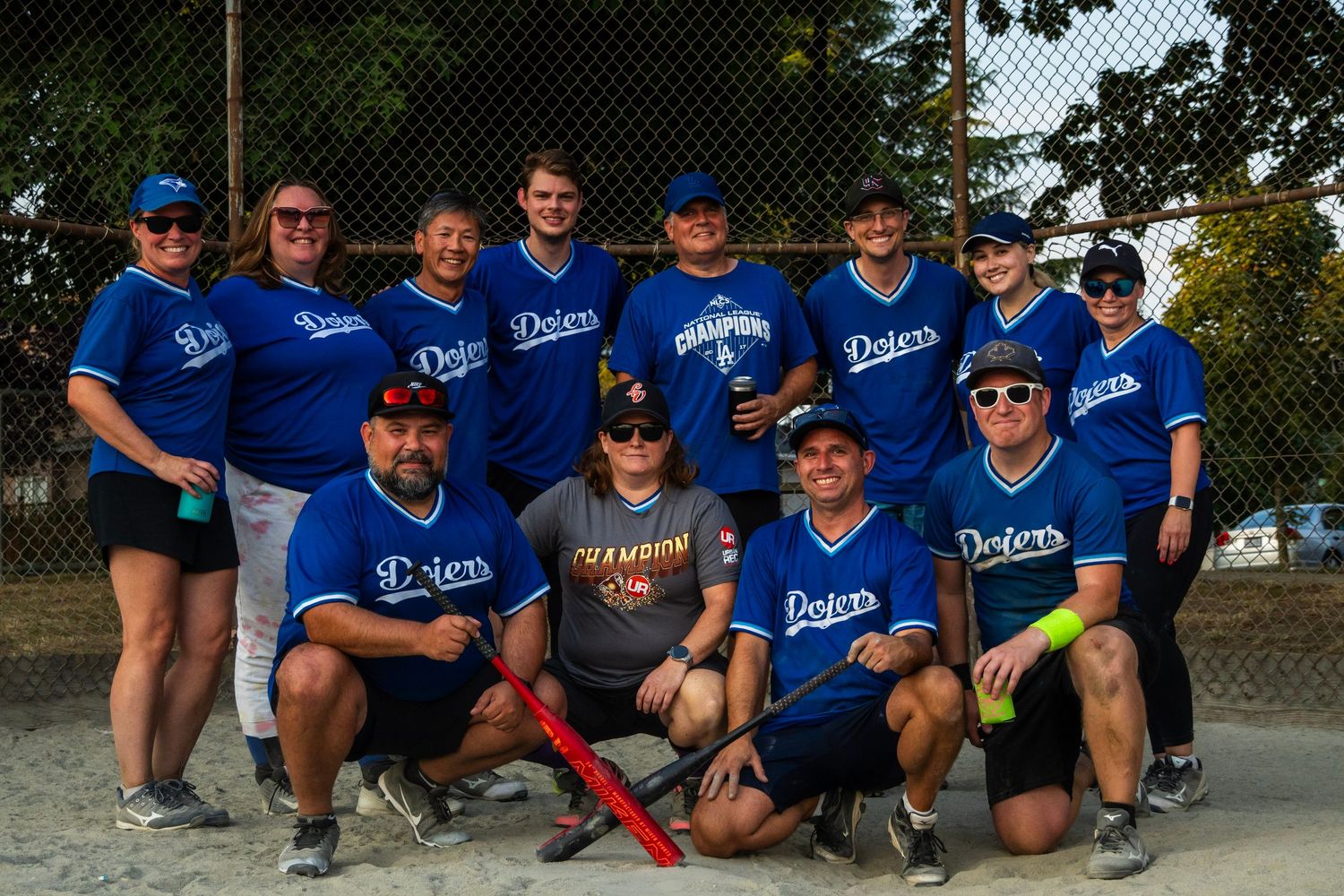 Dodgers recreational softball team poses together for group photo on sunny day.
