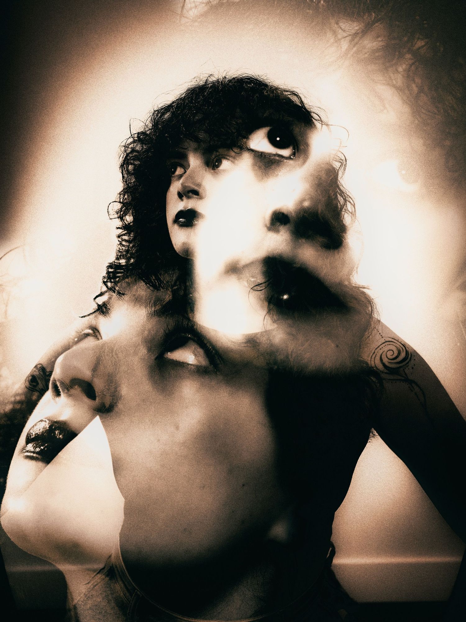 Surreal double exposure sepia portrait of a woman with curly hair and tattoo, multiple face overlay.