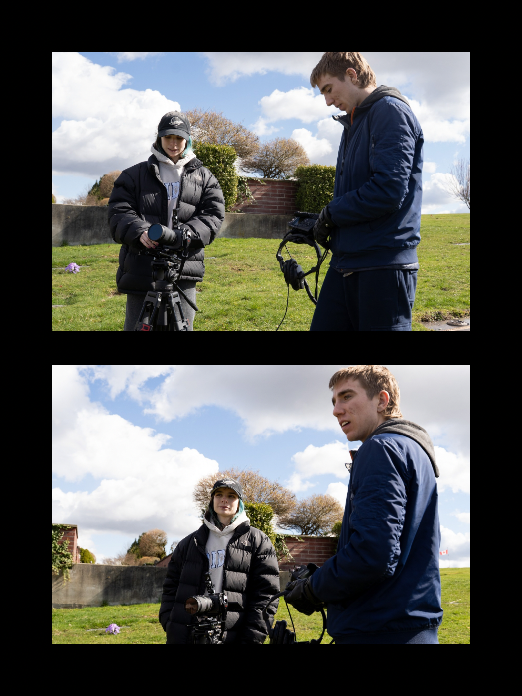 Two young men outdoors on a grassy field holding camera equipment on a cloudy day.