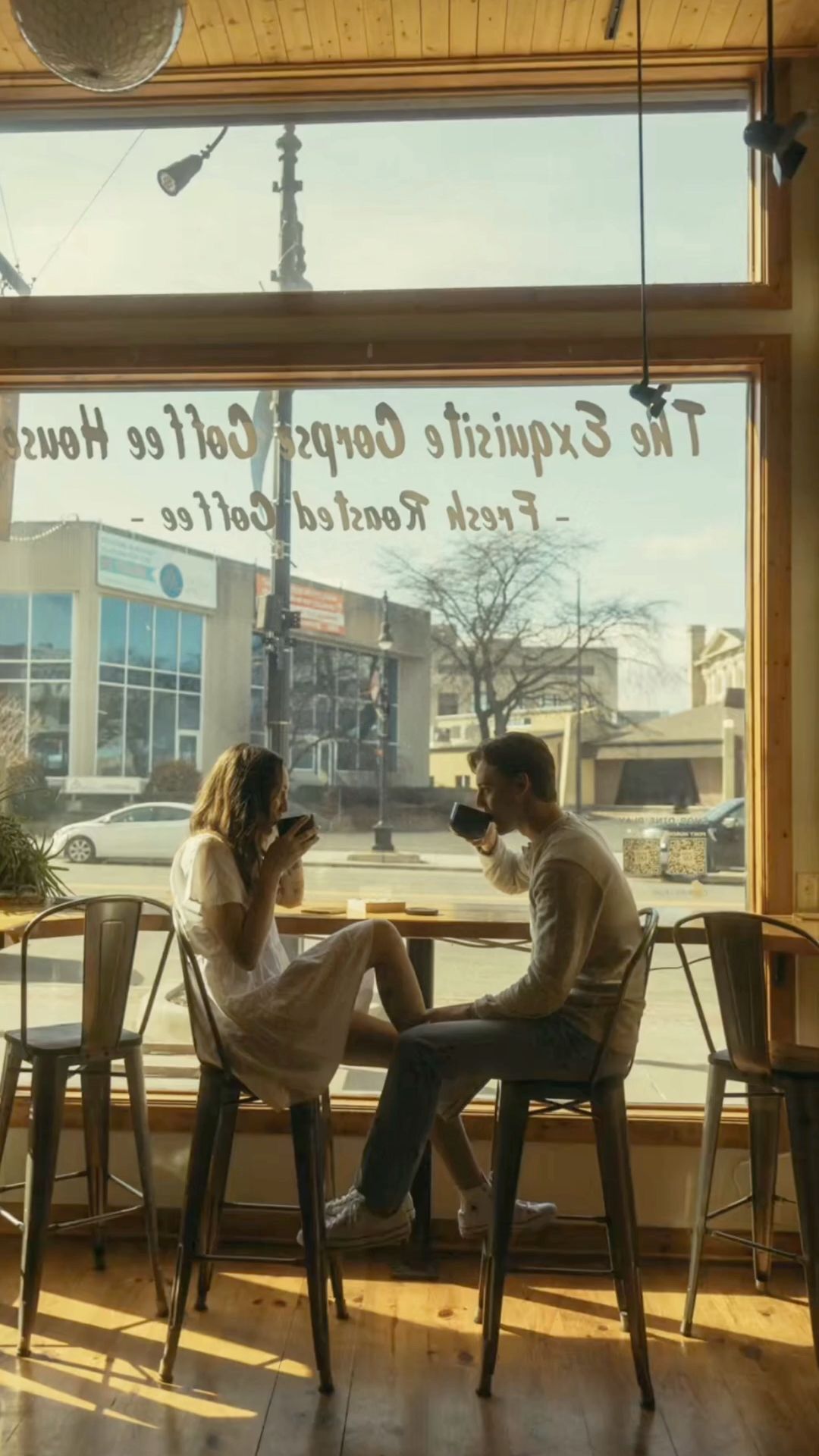 Couple enjoying coffee together at a sunny window seat in The Exquisite Corpus Coffee House cafe.