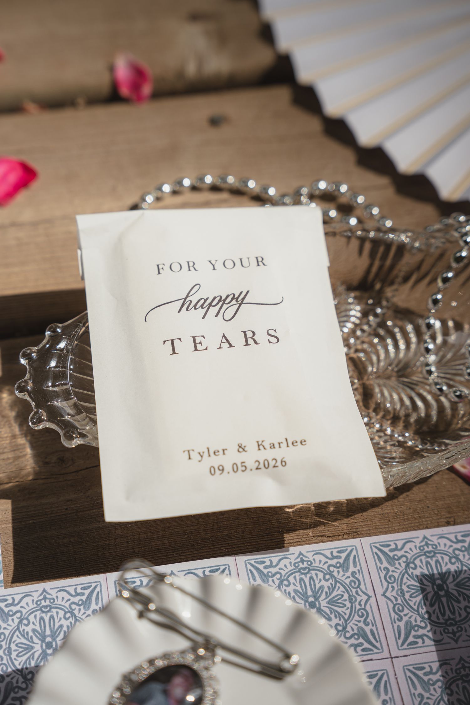 Personalized happy tears packet for Tyler and Karlee wedding on 09.05.2026, displayed on rustic wooden tray.