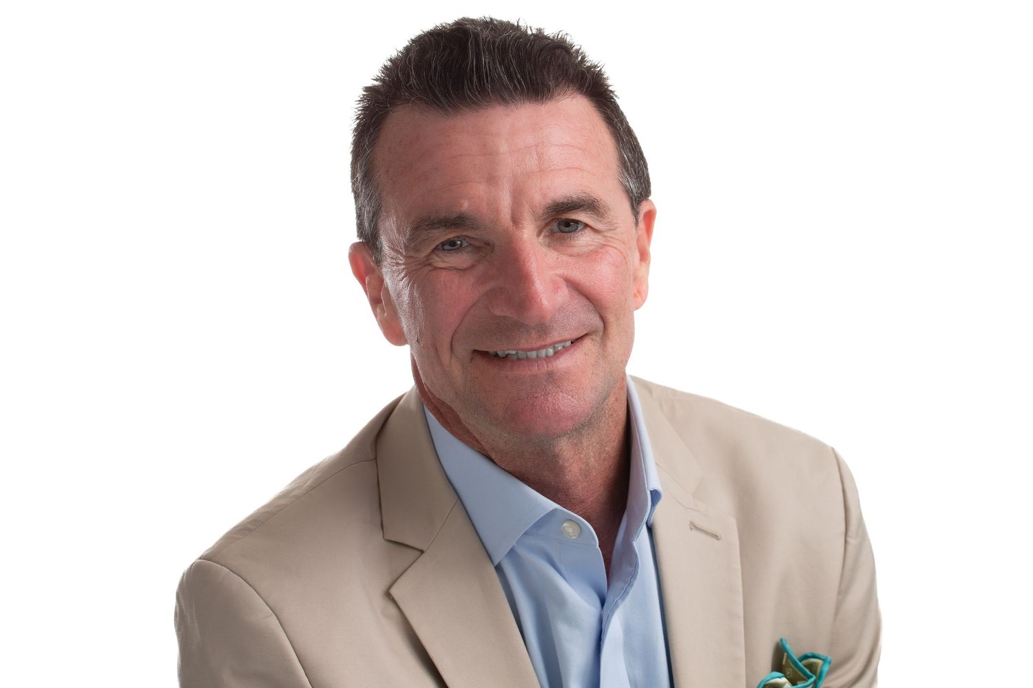 Professional headshot of man in beige suit jacket with friendly smile.