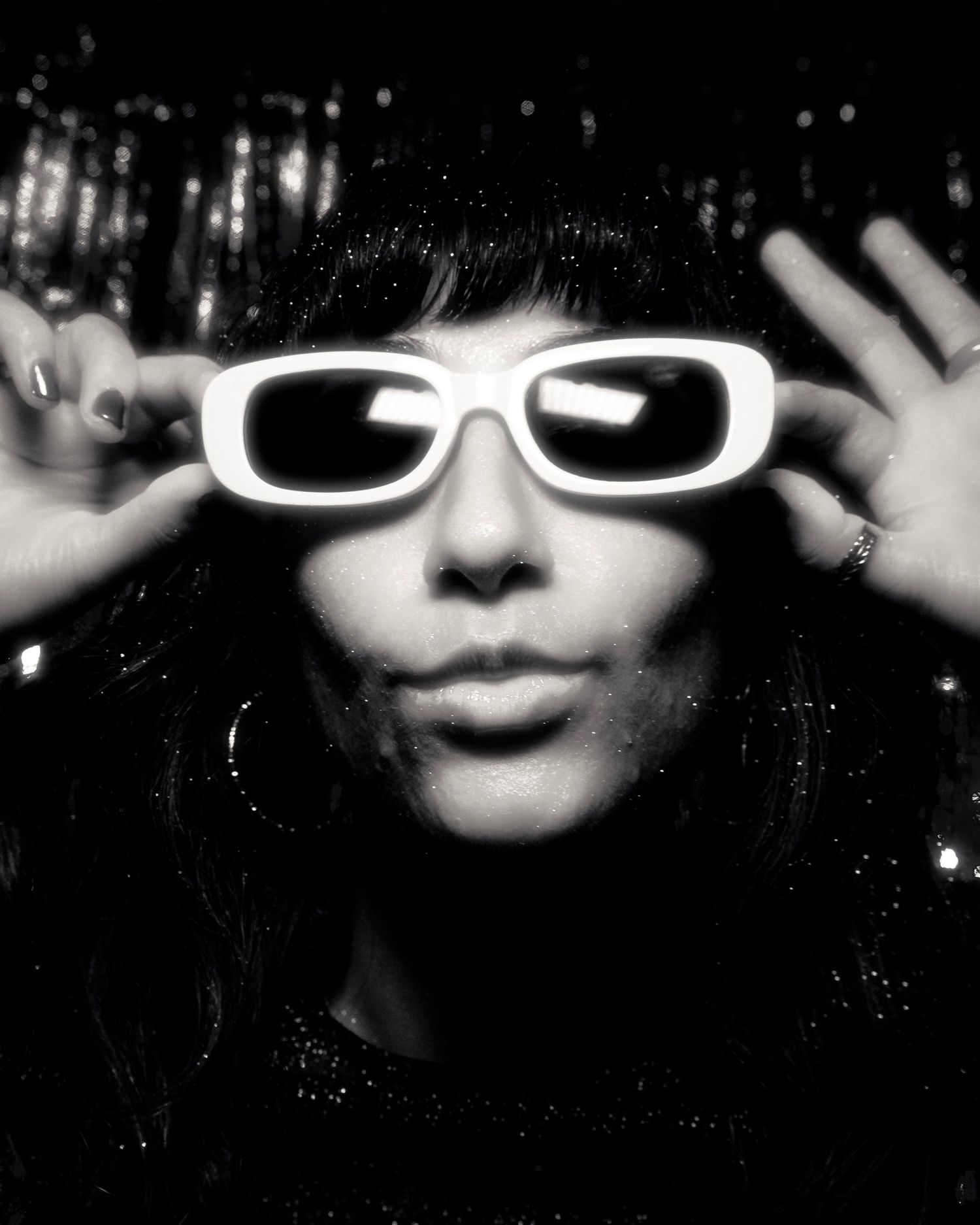 Stylized black and white portrait series with white sunglasses against sparkly background.