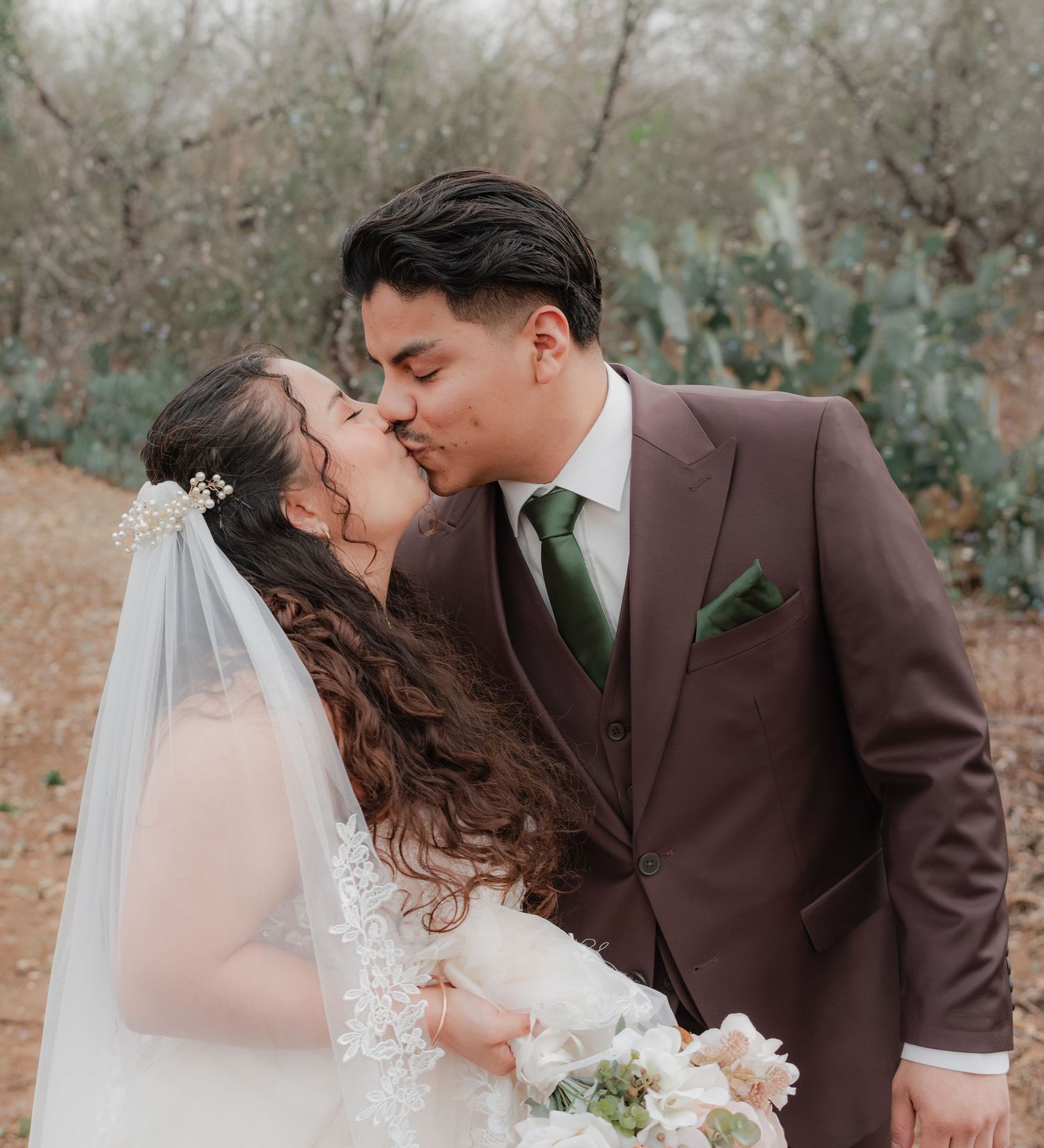 Wedding kiss in an outdoor winter garden—romantic bride and groom in elegant formalwear, soft natural light, cinematic close-up.