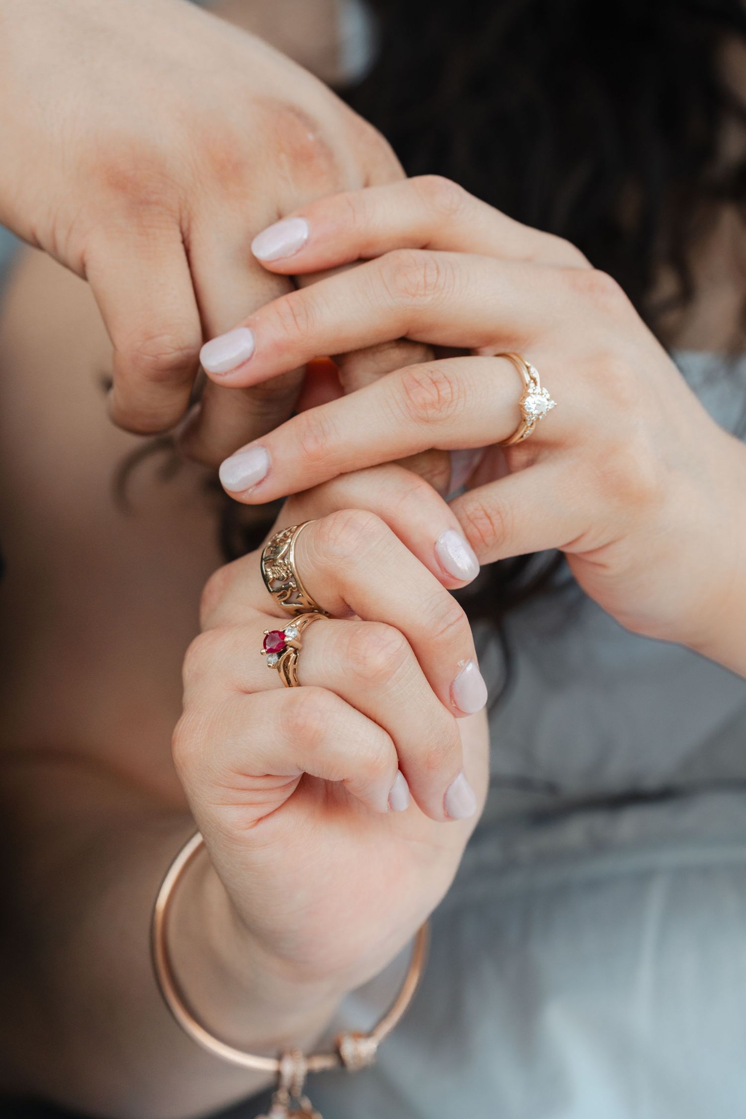 Close-up series of hands exchanging rings with gemstones and diamonds during a wedding ceremony.