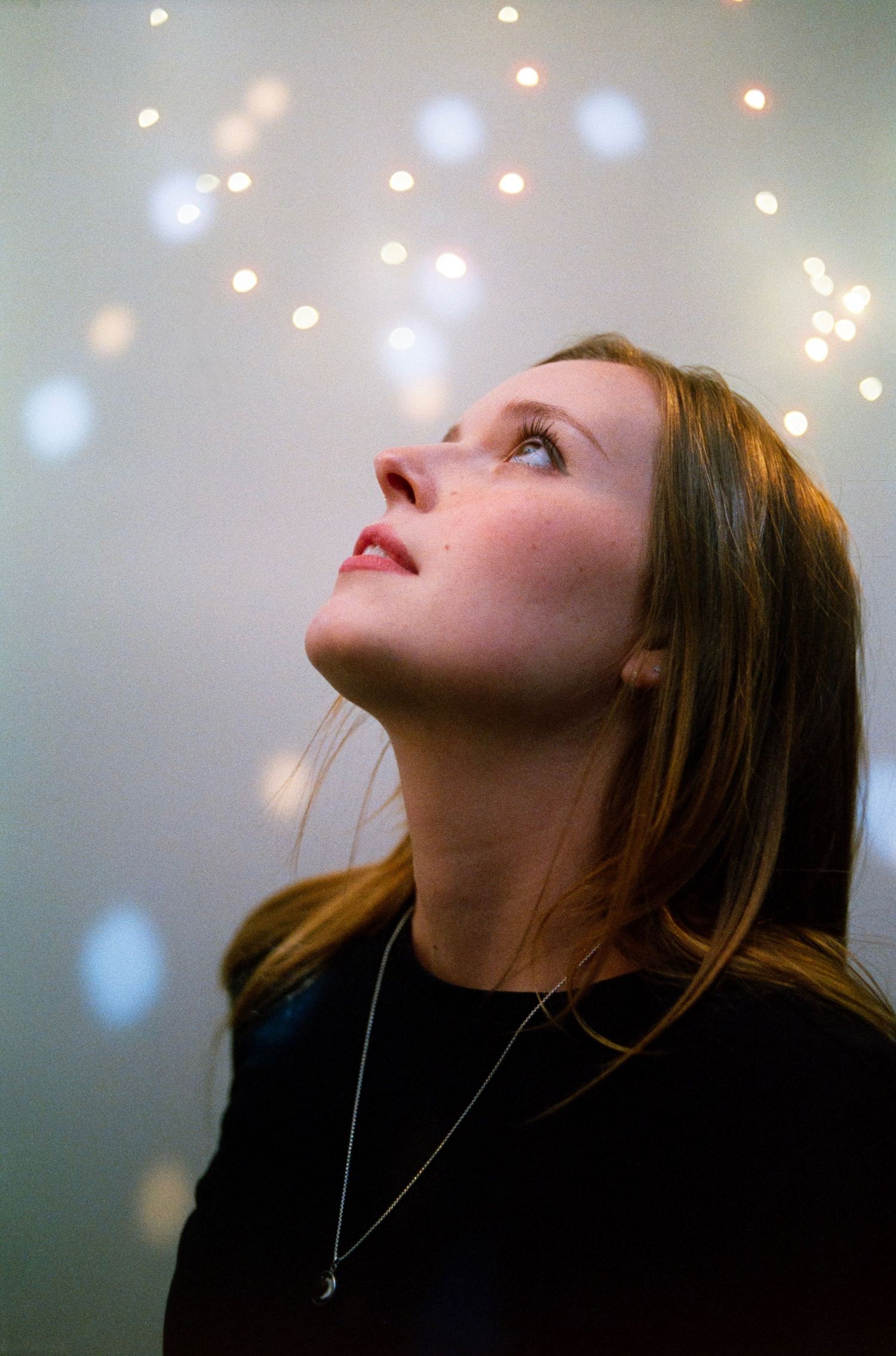 Portrait with soft bokeh lights creating an ethereal atmosphere.