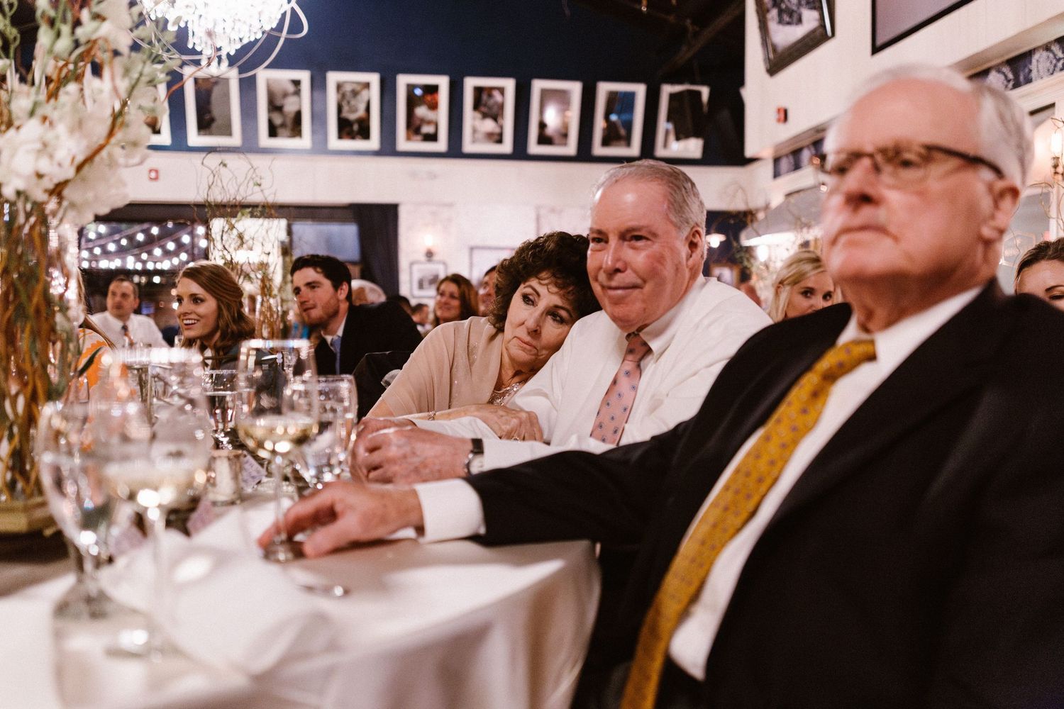 Couple leans together affectionately at a wedding reception dinner table with elegant decor.