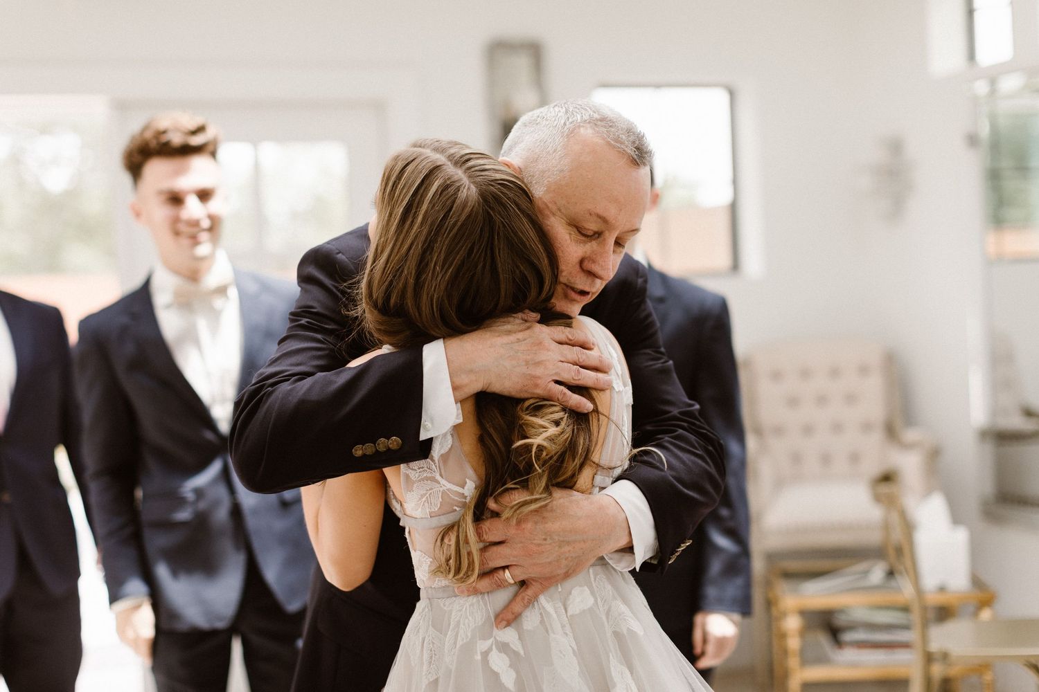Emotional father hugging bride in a heartfelt first look moment on wedding day.