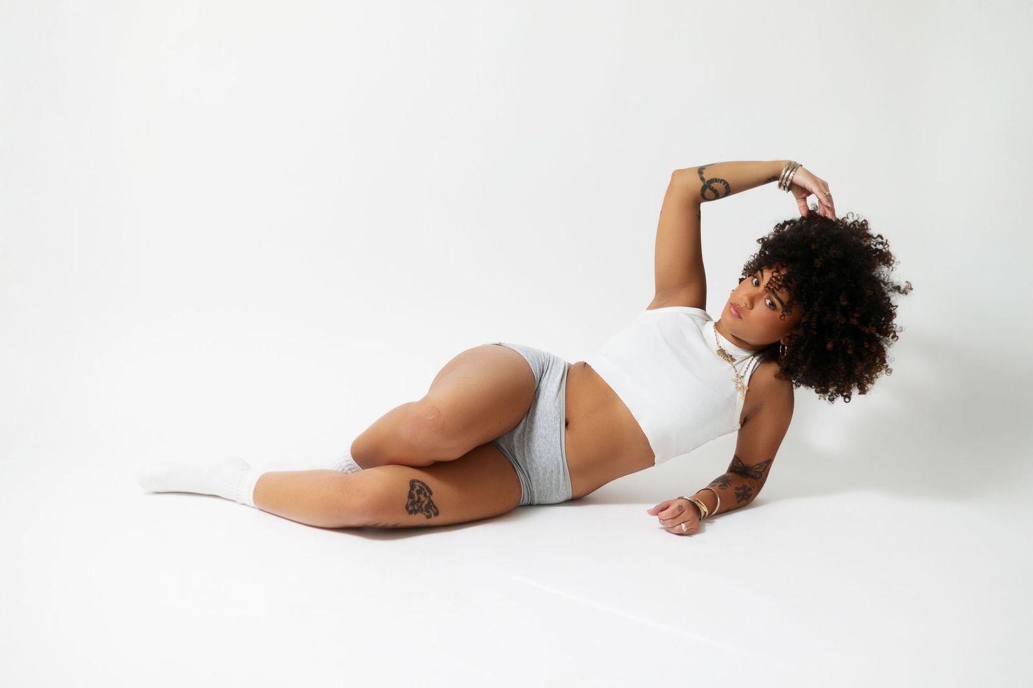 Artistic black and white photo of a figure in minimalist poses against white background.