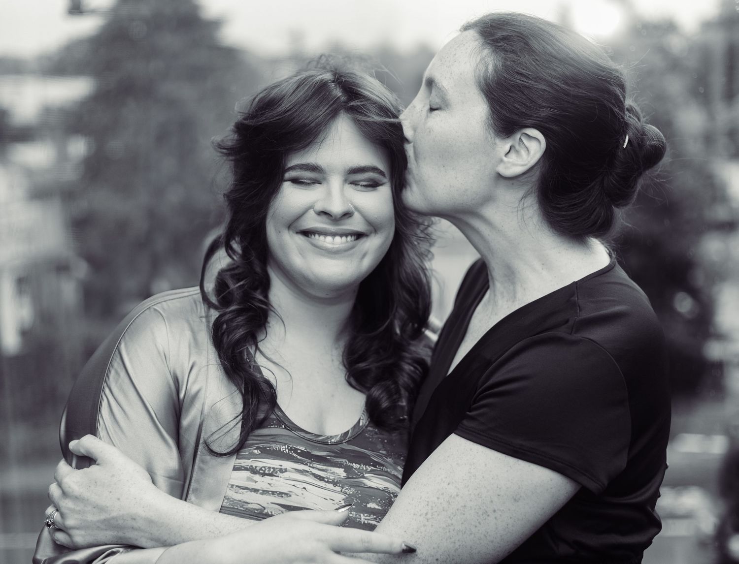 Candid black and white photograph capturing joyful moment between two people.