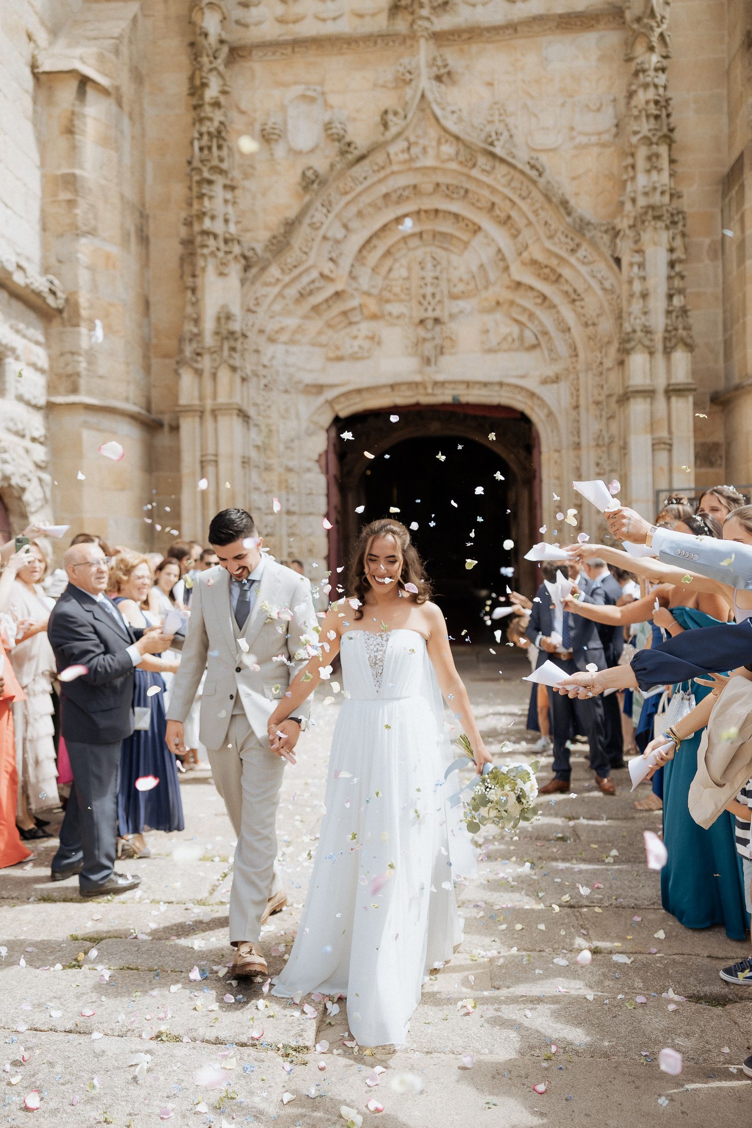 Casamento na igreja Matriz de Barcelos.  Convidados atiram pétalas de flores sobre os noivos.