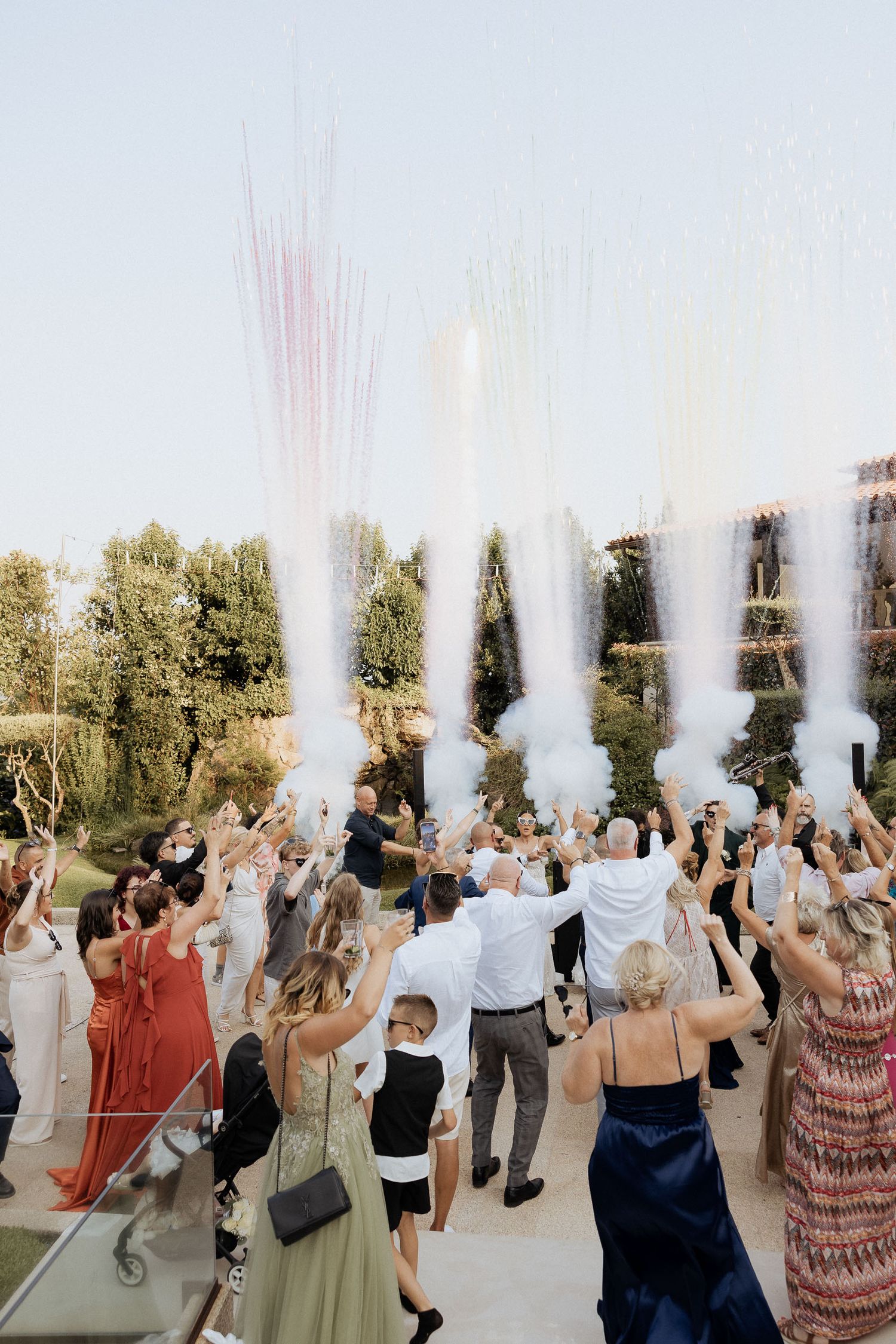 Convidados de casamento celebram ao ar livre com canhões de confete e serpentinas em um elegante local de recepção com jardim. Quinta da Pia