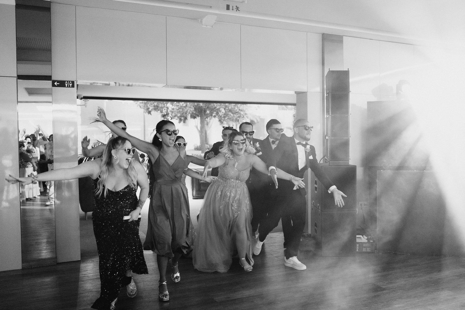 Foto em preto e branco de convidados de casamento dançando e celebrando com alegria em um local de recepção na Quinta do Carvalho.
