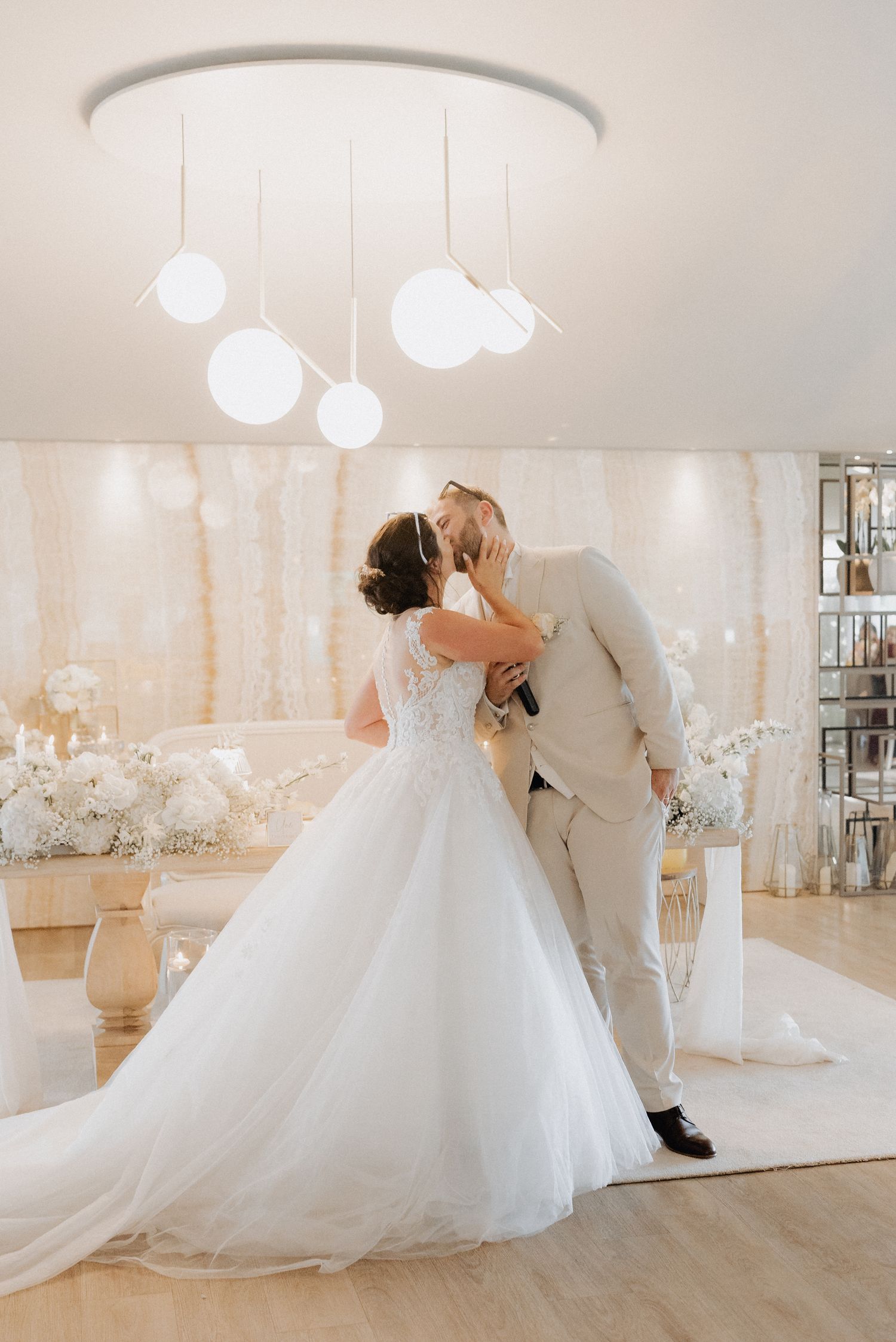 Noiva e noivo a trocarem um beijo romantico num elegante salão cheio de flores na Quinta de Santo André
