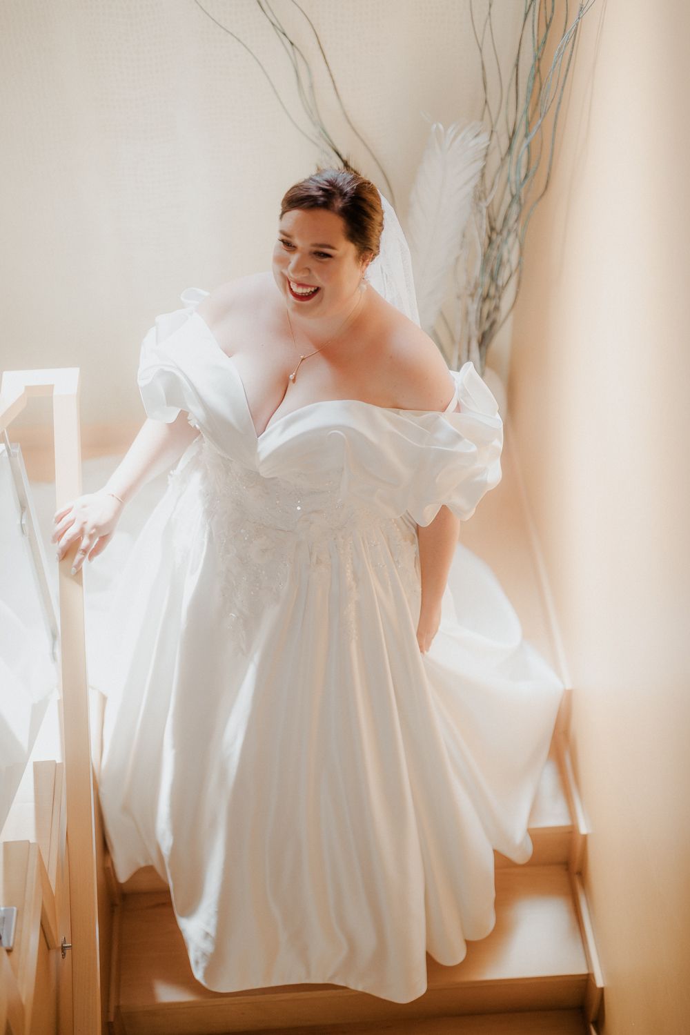 Noiva sorridente num vestido de noiva branco a descer as escadas a caminho do casamento na Quinta do Carvalho em Viana do Castelo