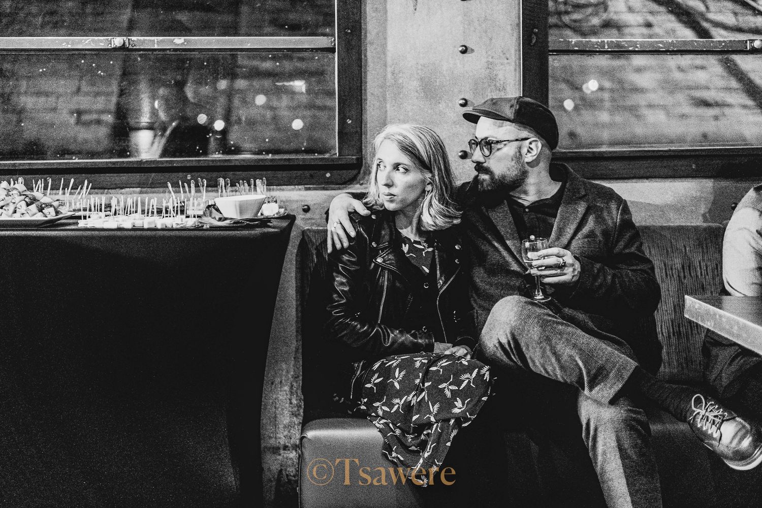 Couple sitting together in a bar, black and white candid photography.