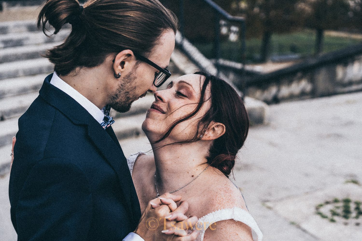 Bride and groom sharing a romantic moment, holding hands and almost kissing on wedding day.