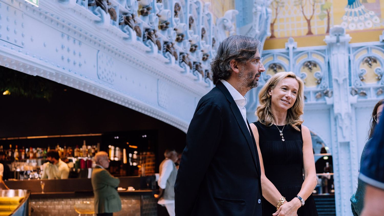 Couple admiring the ornate Art Nouveau architecture inside Samaritaine Paris.