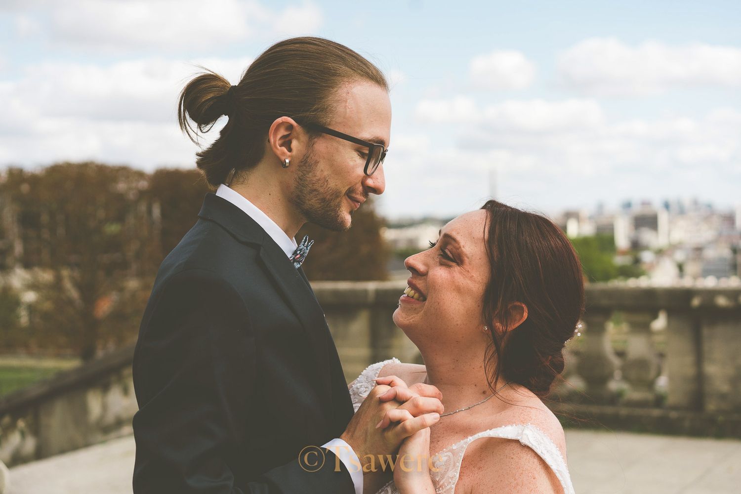 Bride and groom sharing a joyful intimate moment together on sunny outdoor terrace.