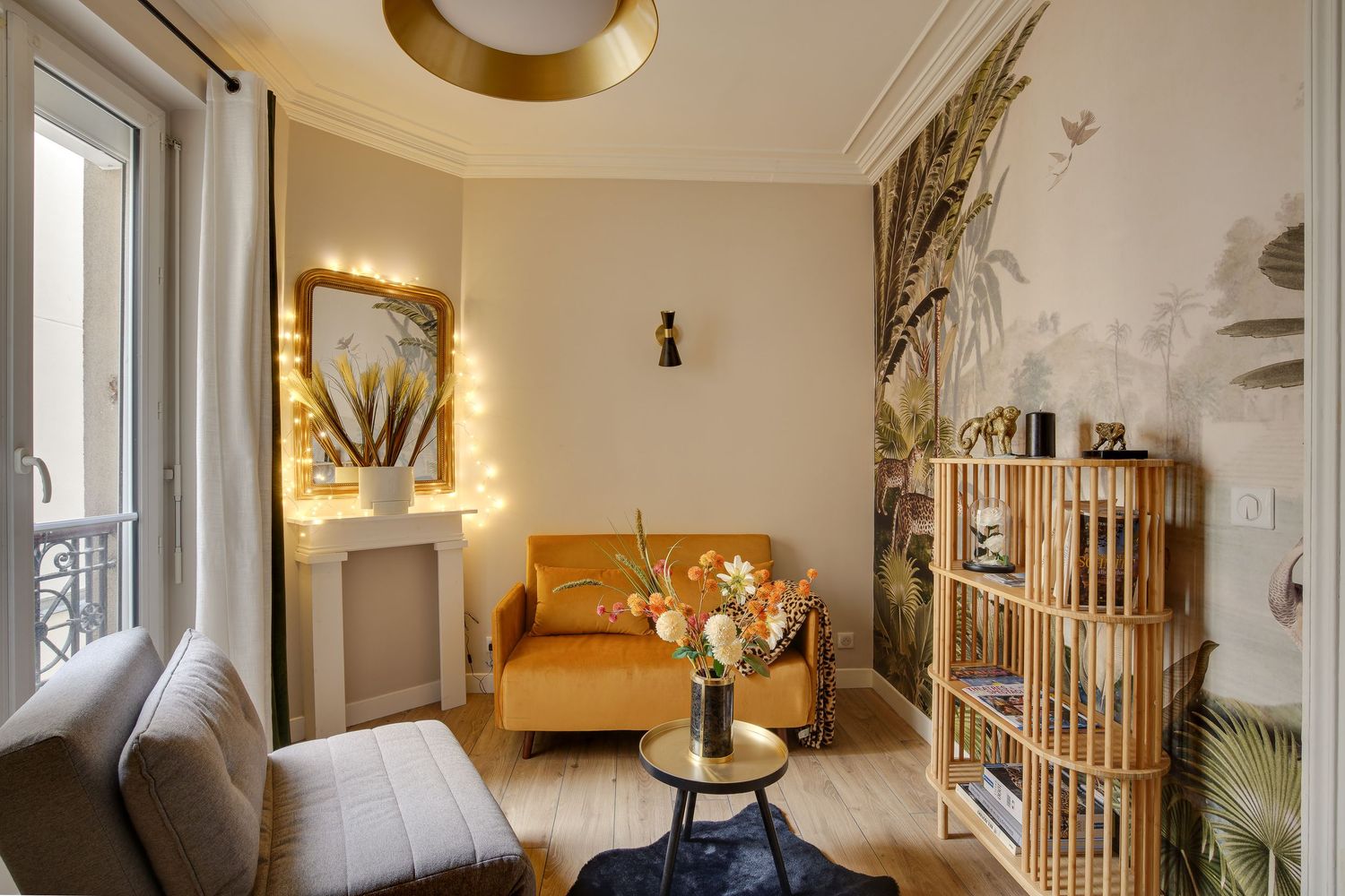 Cozy modern living room with mustard yellow sofa, botanical wallpaper, and warm ambient lighting in Paris.
