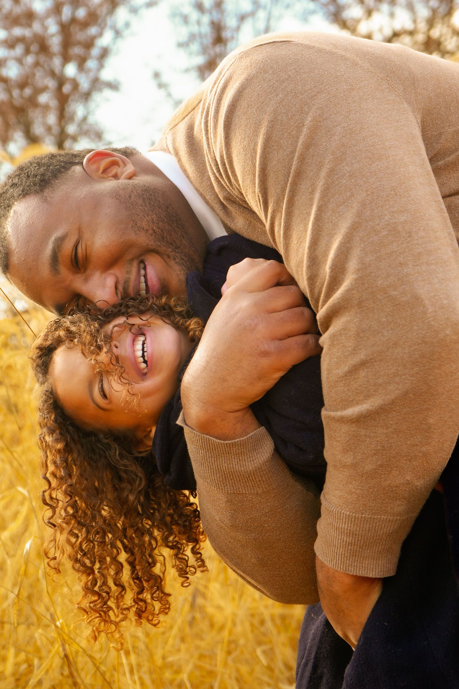 Playful moments captured in golden sunlight against natural outdoor backdrop.