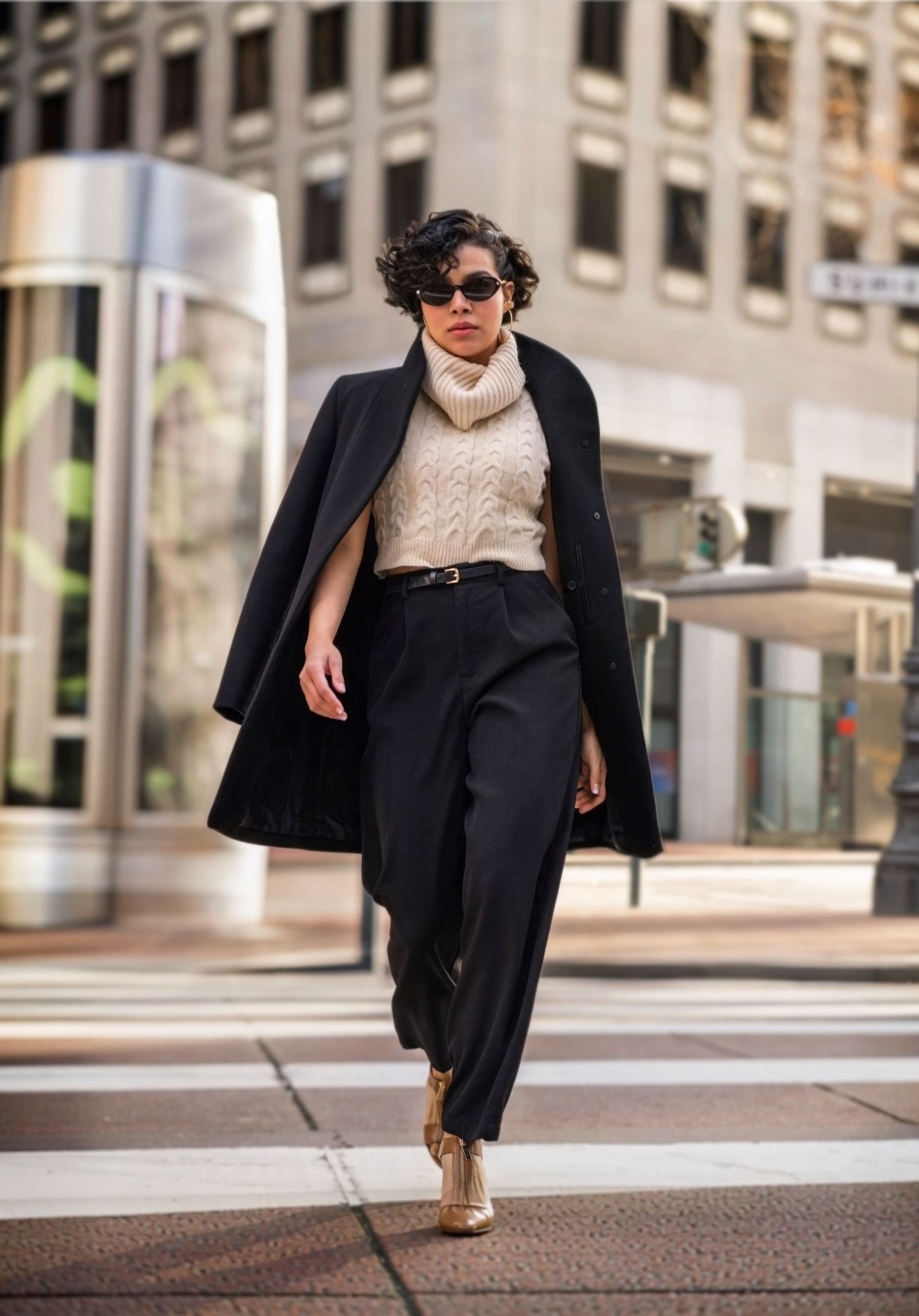 Stylish winter outfit featuring a black coat, cream turtleneck sweater, wide-leg trousers and leopard print heels on city street.