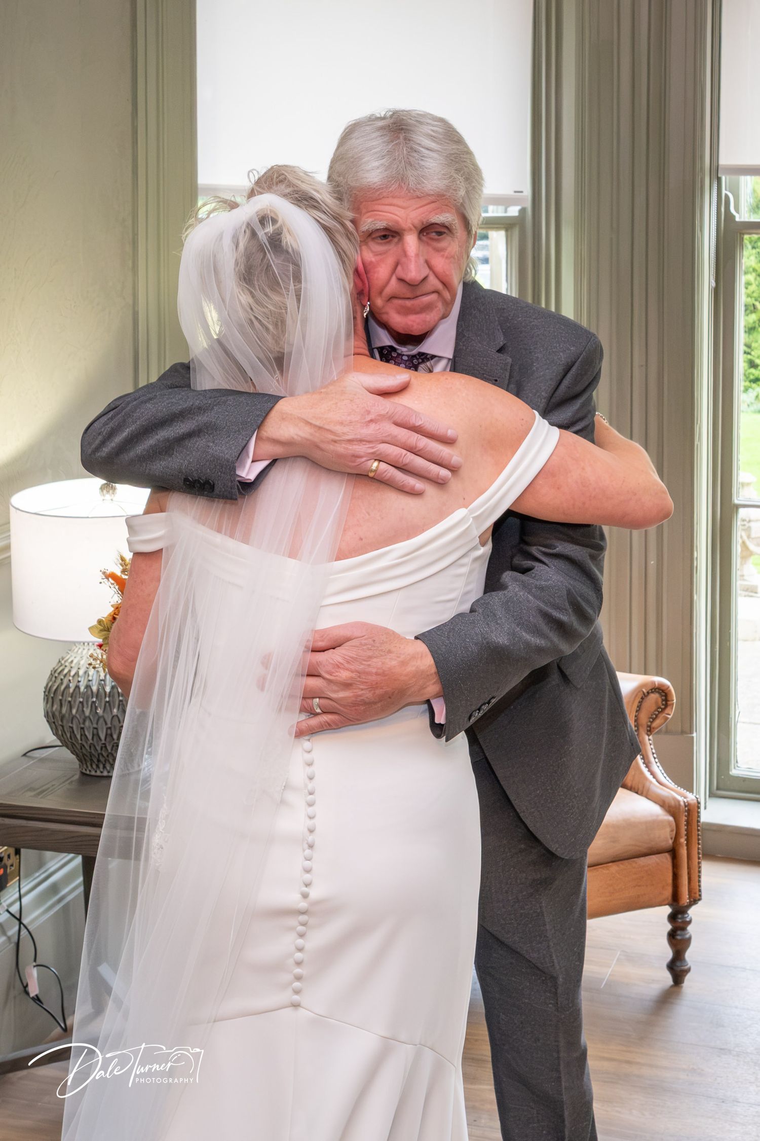 Tender moment captured during a wedding in an elegant indoor setting.