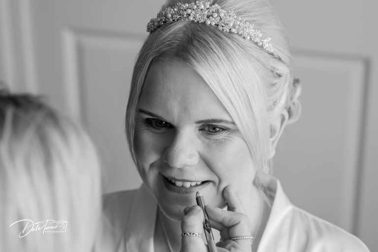 Black and white portrait of a bride wearing a tiara and smiling.