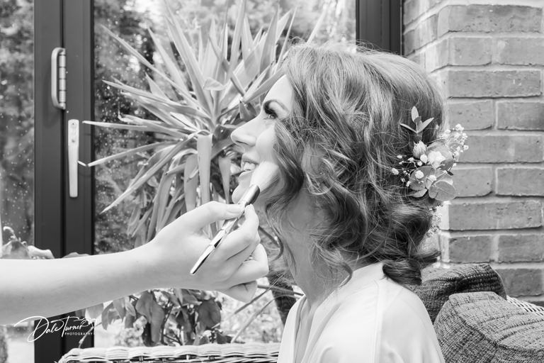 Wedding party poses for candid black and white photographs outdoors.
