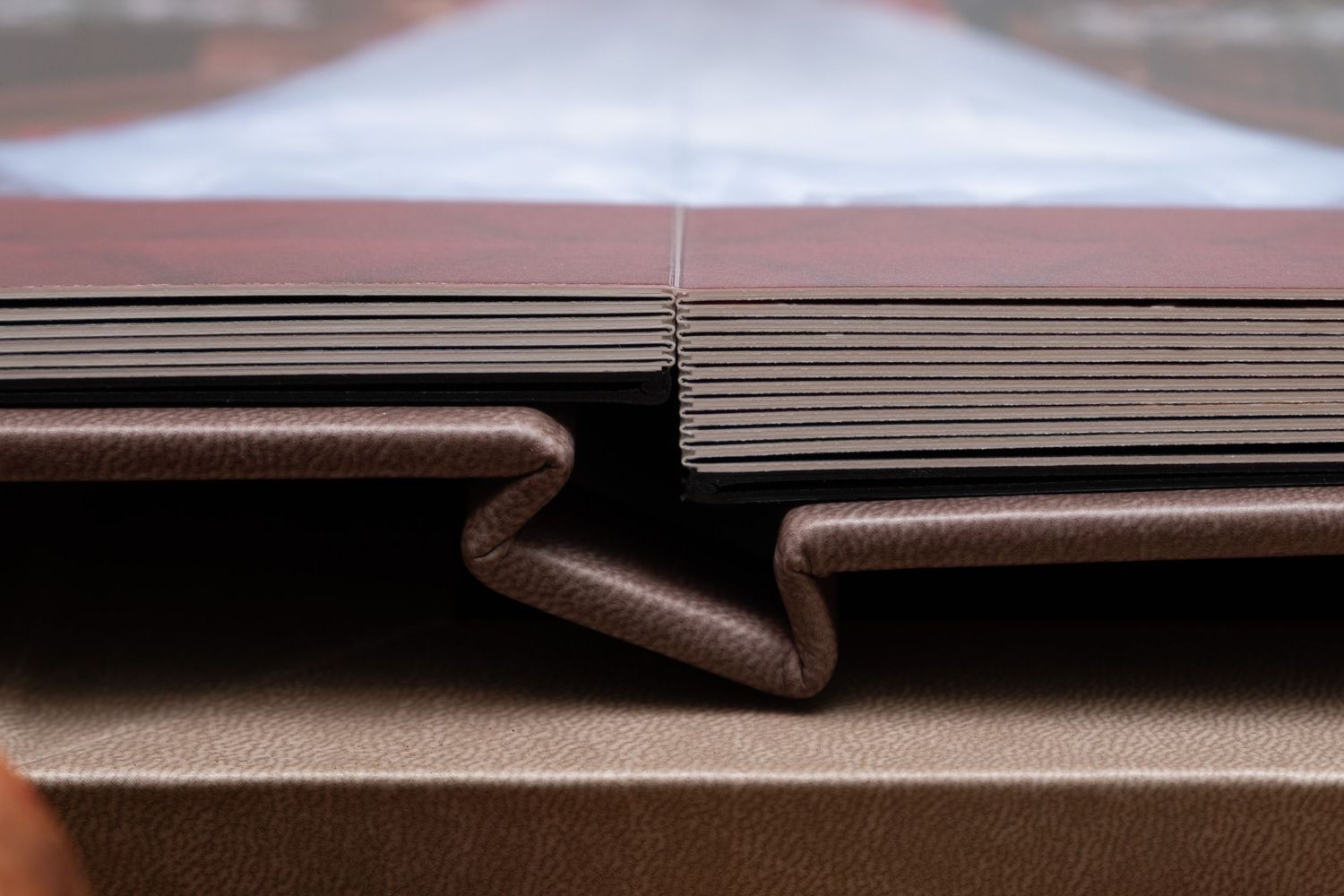 Close-up detail of a leather-bound wedding album with embossed cover and textured pages.