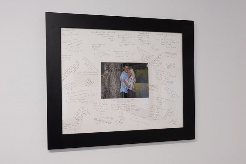 Modern black framed artwork displayed on a light gray wall.