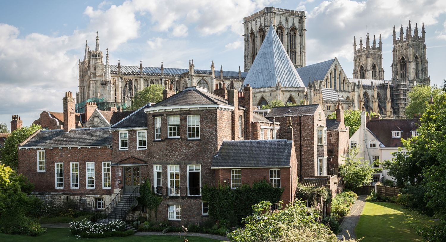 Historic York Minster cathedral towers over traditional brick buildings in an architectural cityscape.
