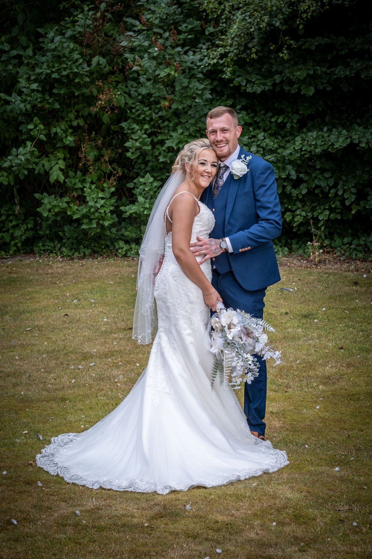 Intimate wedding portrait session on a grassy lawn with flowing white dress.
