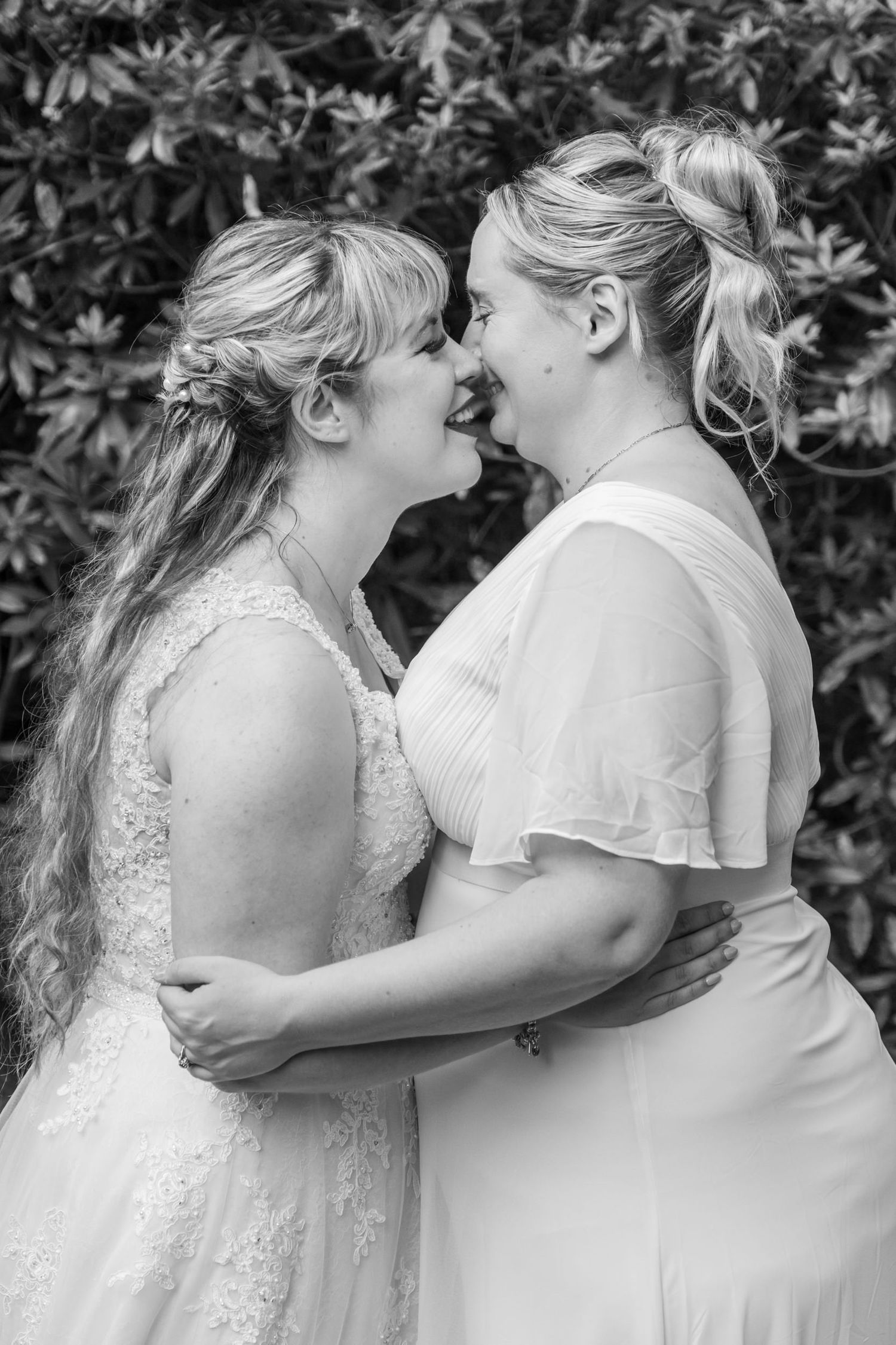 A series of black and white romantic wedding photos showing tender moments between two people in white dresses.