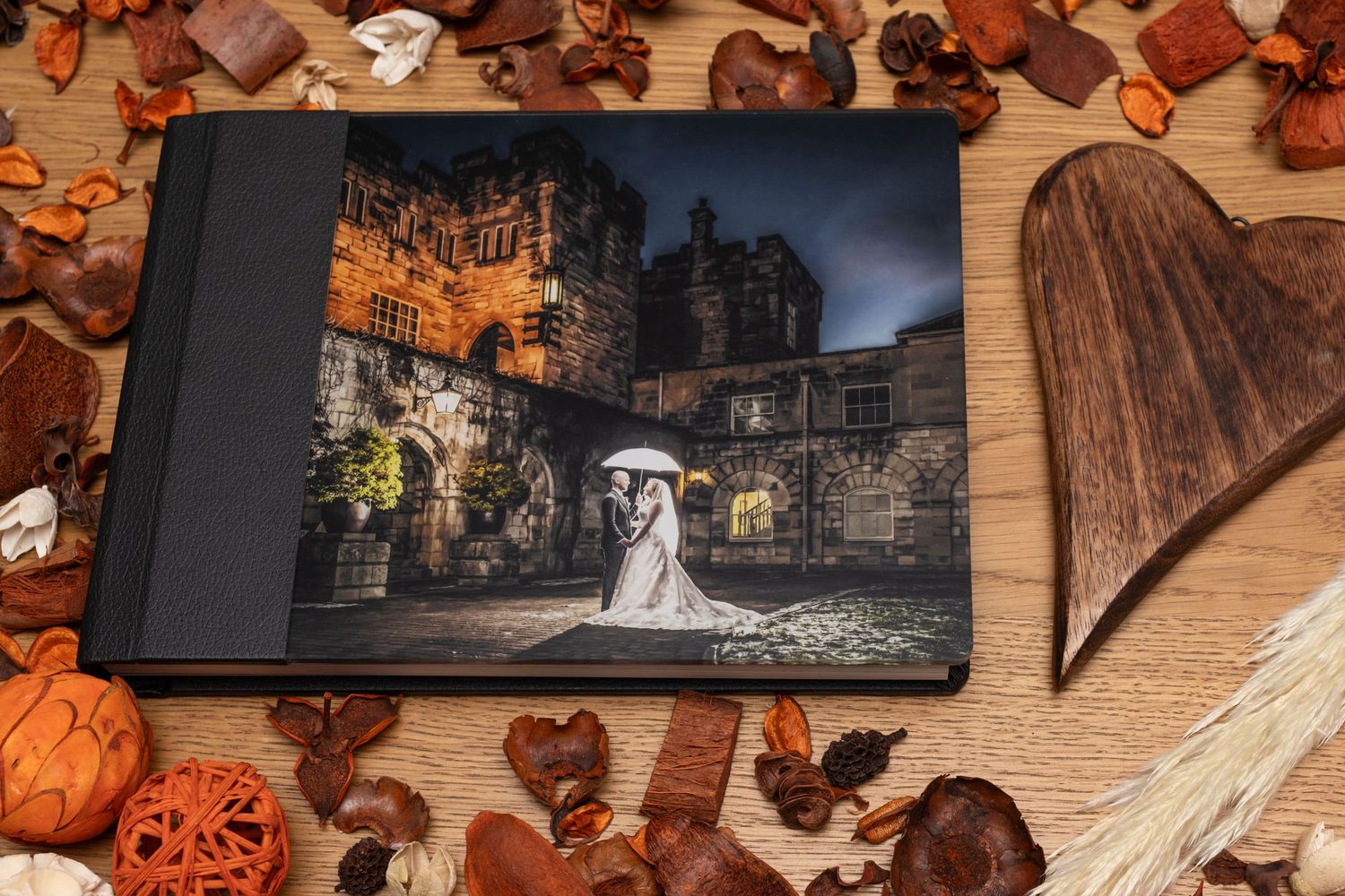 Professional wedding photography prints arranged with seasonal fall decor and pumpkins.