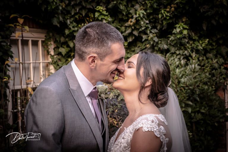 Romantic wedding portraits captured in garden setting with natural greenery backdrop.